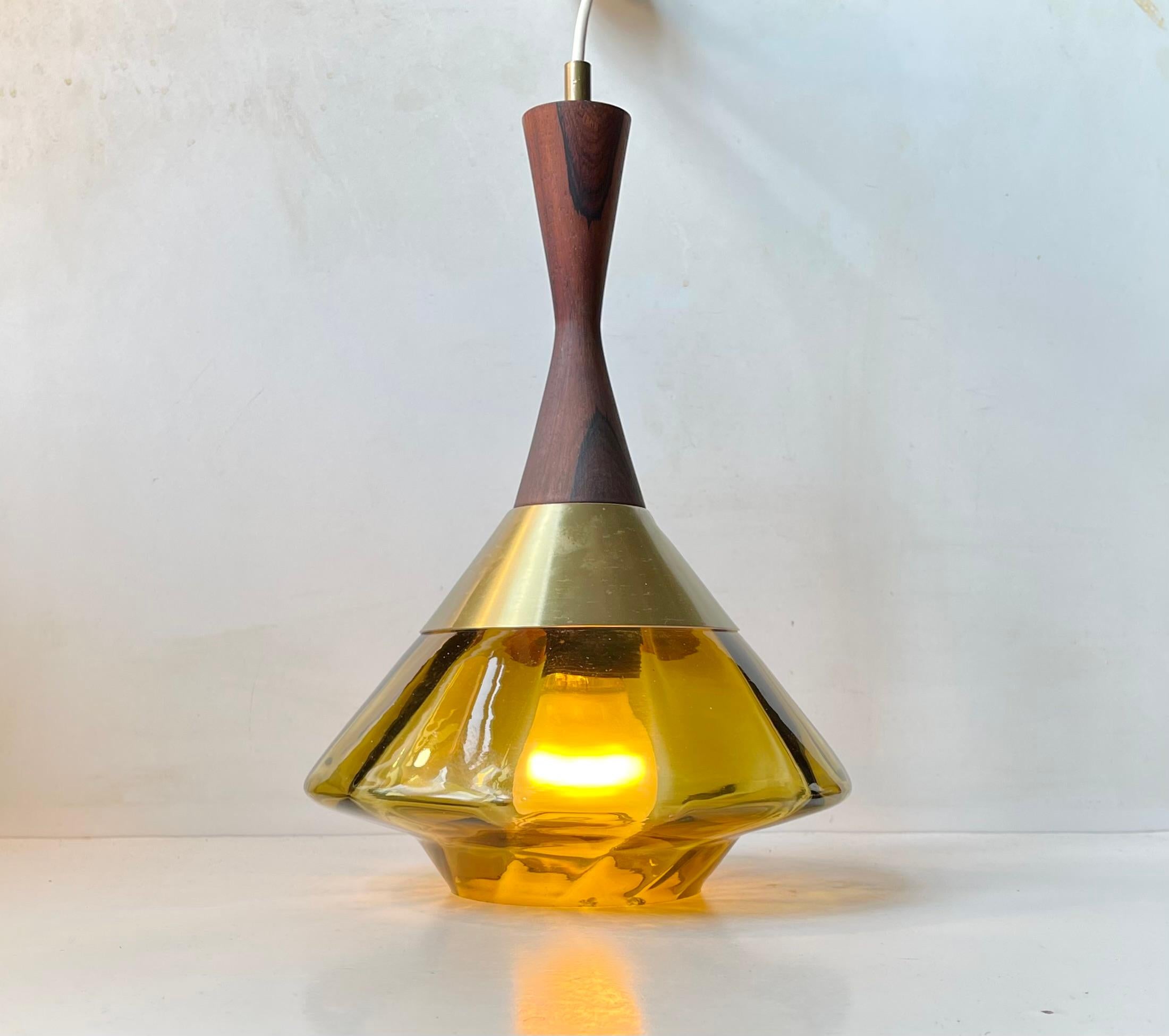 A diablo shaped hanging light with hand-blown pickle/olive green main glass shade and a top in solid rosewood set in brass-alloy aluminum. Manufactured by Orrefors in Sweden during the 1960s. It may have been designed by Carl Fagerlund (uncatalogued