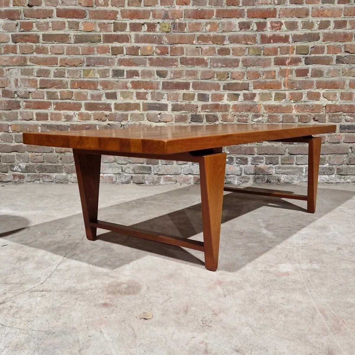 Dinner table in solid teak designed by Illum Wikkelsø in Denmark. The wood presents a beautiful grain on the table top, and the thick footing gives the table a unique geometrical look. 
