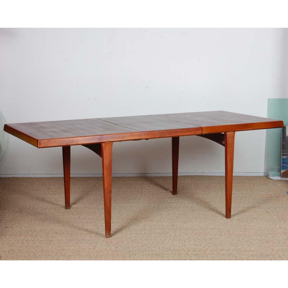 This Scandinavian vintage dining table dates from the 1960s. It features an integrated extension under the tabletop, also known as a butterfly extension. It measures 50 cm. This teak dining table has been restored.
