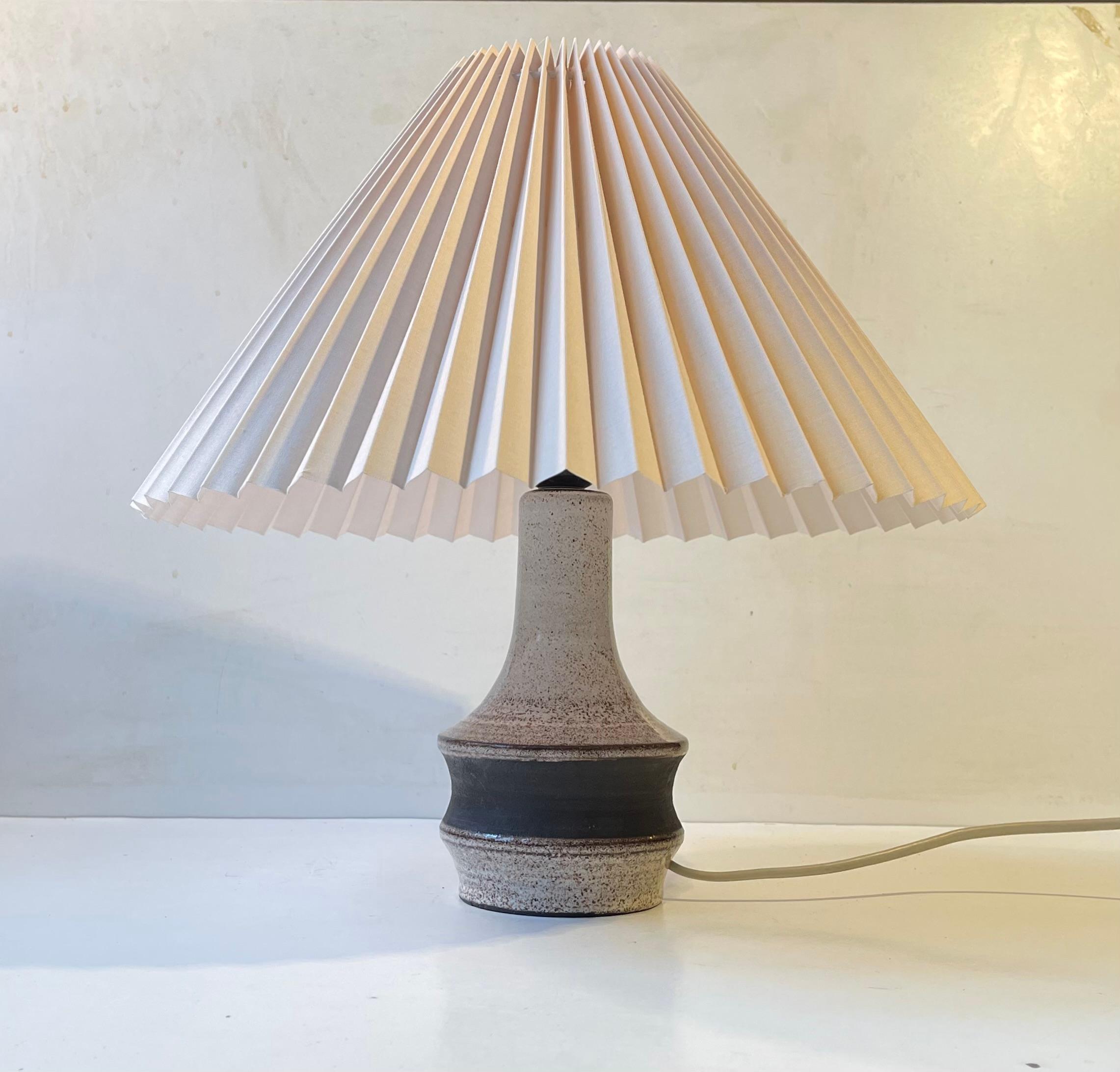 Stoneware table light decorated in earthy speckled dark brown glazes upon a creme white background. It has no signature or markings but it was probably made in Denmark or Sweden during the 1970s. The styling of this light is very much in vogue with