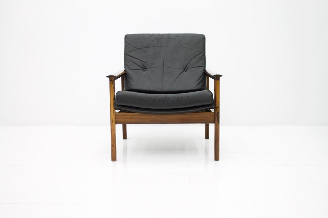 Scandinavian lounge chair in Wood and black leather with loose cushions. The back of the armchair is also covered with black leather.
Dimensions: W 69 cm (27 inches), D 77 cm (30.3 inches), H 89 cm (35 inches), SH 42 cm (16.5 inches).
Good to very