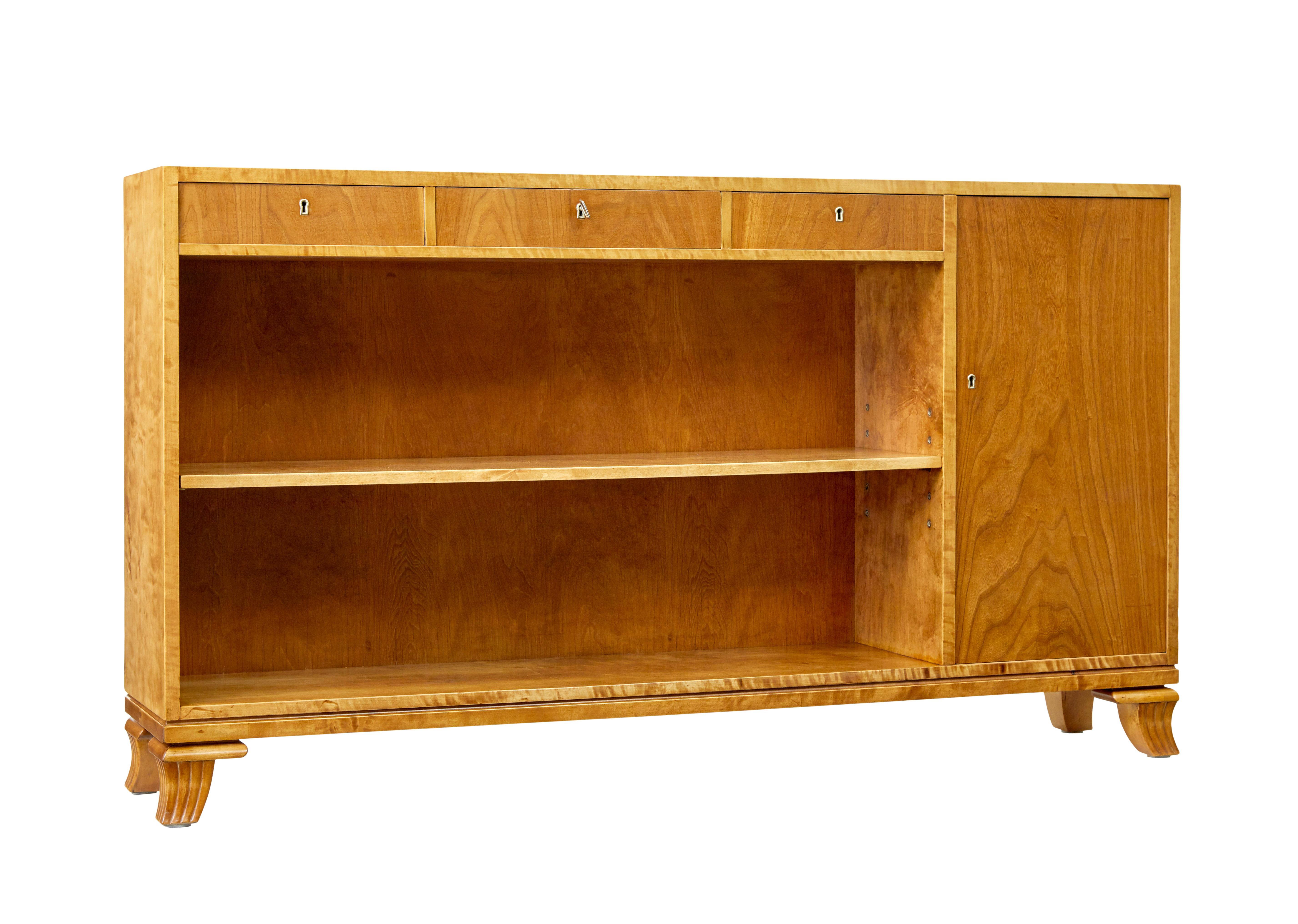 Bibliothèque ouverte basse scandinave en orme et bouleau vers 1950.

Bel exemple de solutions de rangement pour les petits espaces, ou même de support pour les téléviseurs à écran plat.

Corps principal en bouleau avec portes et tiroirs en orme. 