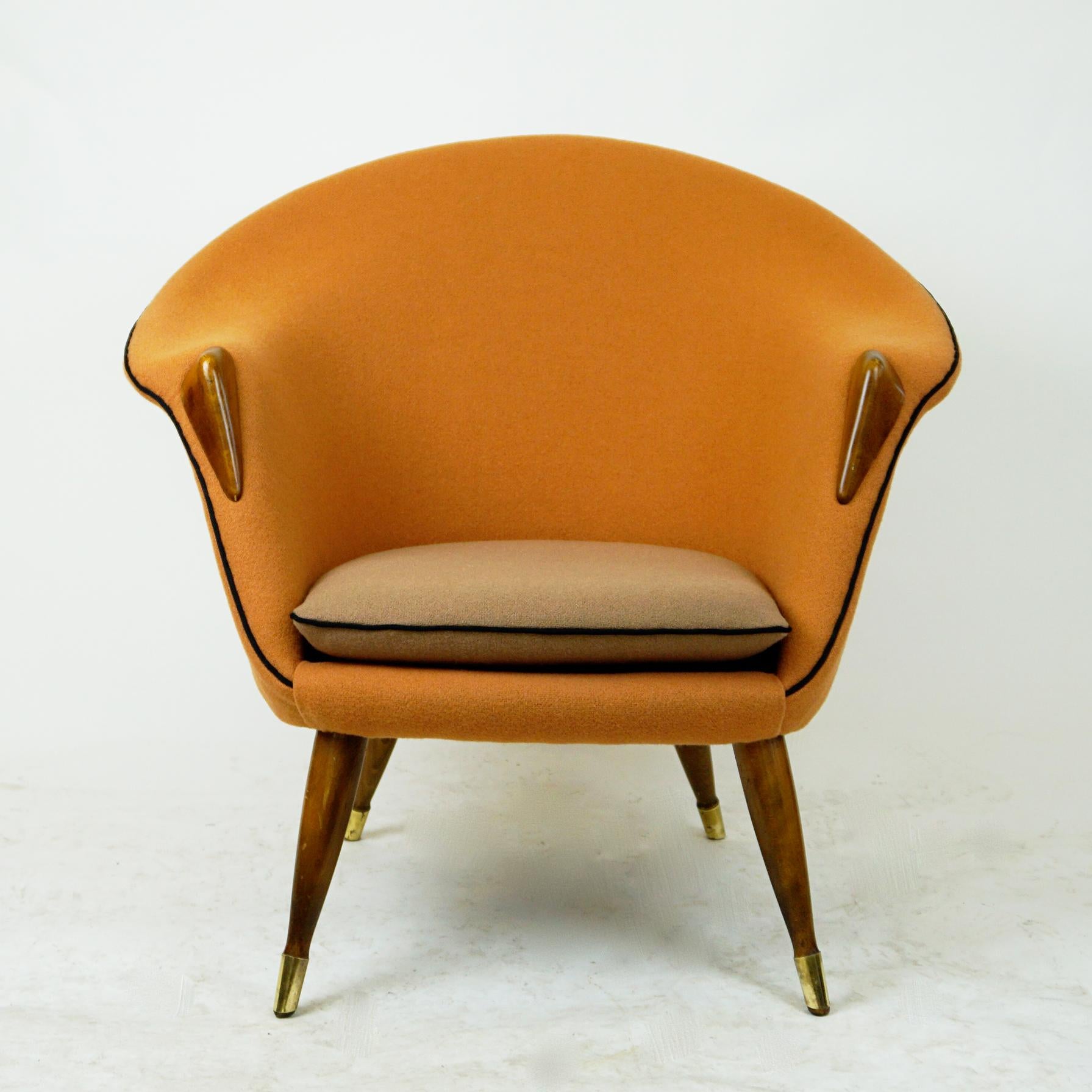 Light and elegantly shaped Danish modern lounge chair. It´s shape is very close to the nursing chair by Nanna Ditzel. The curved shell is professionally re-upholstered in a soft orange and beige wool Kvadrat fabric. The beautiful elm details at the