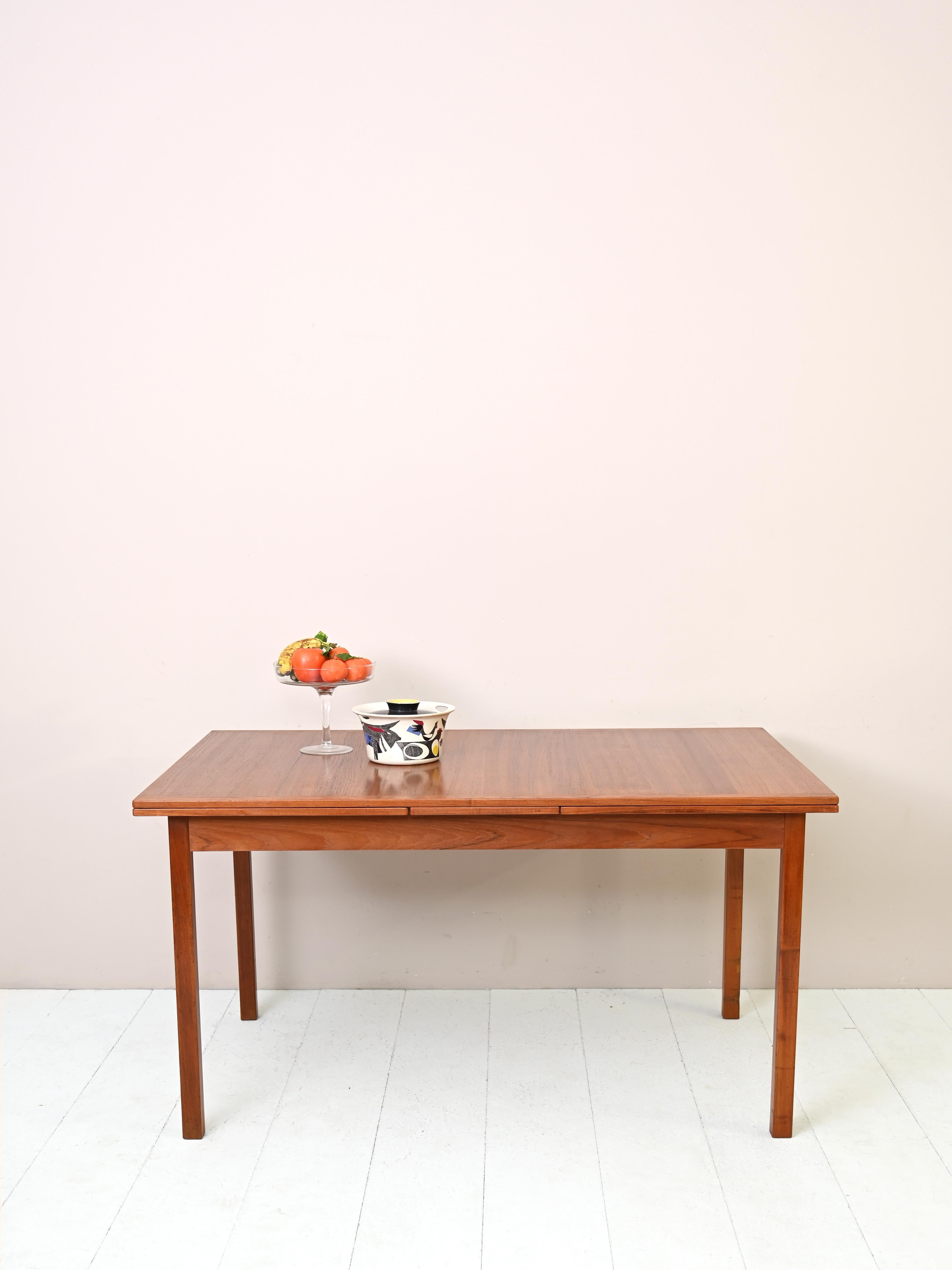 Scandinavian 1960s teak dining table.
 
DIMENSIONS OF PLANKS: 2 X 55cm

A Nordic design piece of furniture with regular, square lines. It can be extended thanks to the two retractable side planks that can be used when needed.
An effective way to