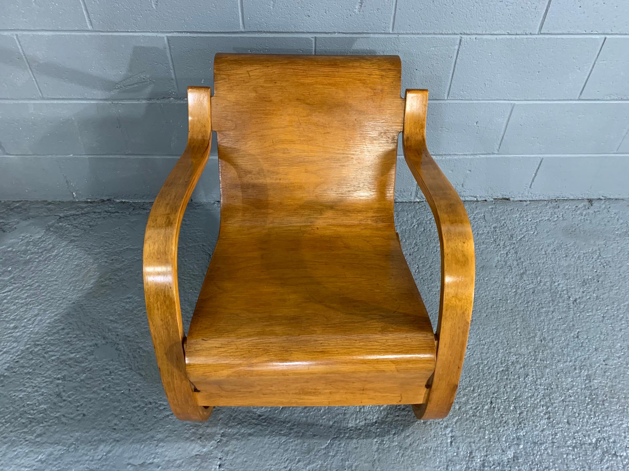 Rare midcentury Finnish lounge chair model 31/42 by Alvar Aalto, given the rich, deep patina of the chair's wood it appears to be a very early production example. This cantilevered lounge armchair model 31/42 is a Scandinavian Modern design icon by