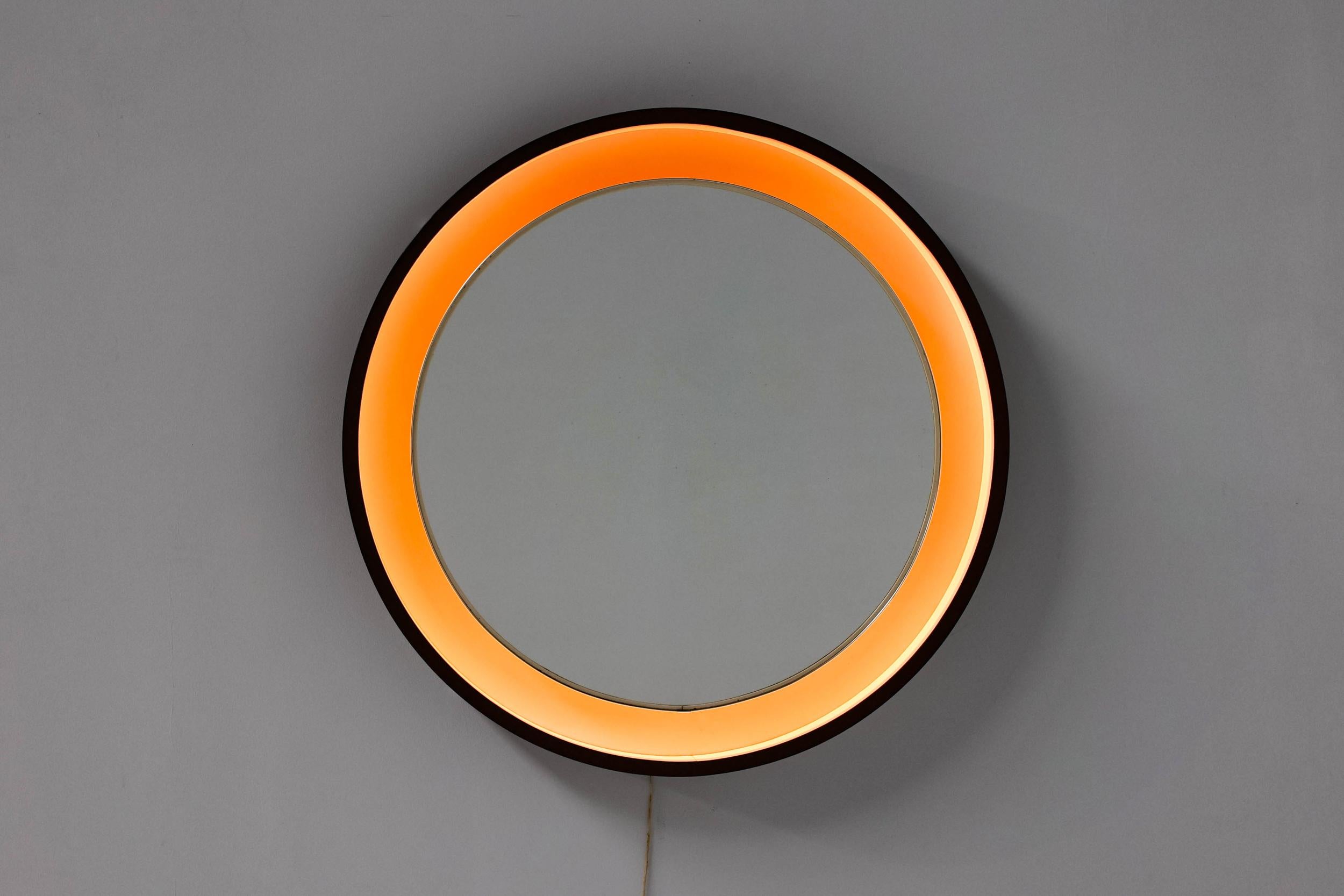Scandinavian Design; 1990's; Round mirror with light; 

Scandinavian round mirror light. Wooden frame with a floating mirror in the middle that is surrounded by light. Ideal make-up mirror for in a bathroom or entryway.