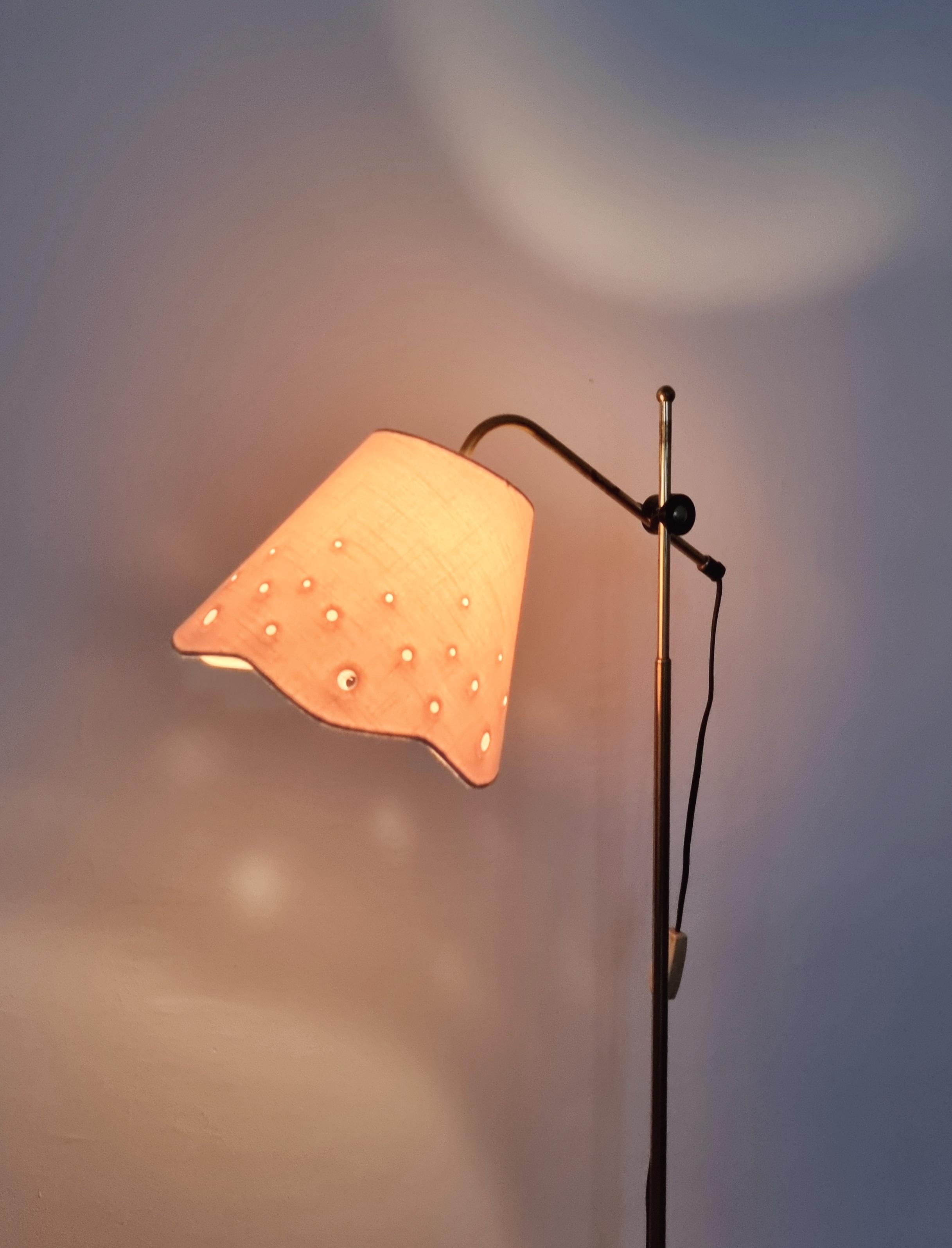 Möllers Armaturfabrik Eskilstuna (MAE), floor lamp in brass and cast iron with plastic details. 

Original beautiful white shade with perforated decorative details. 

