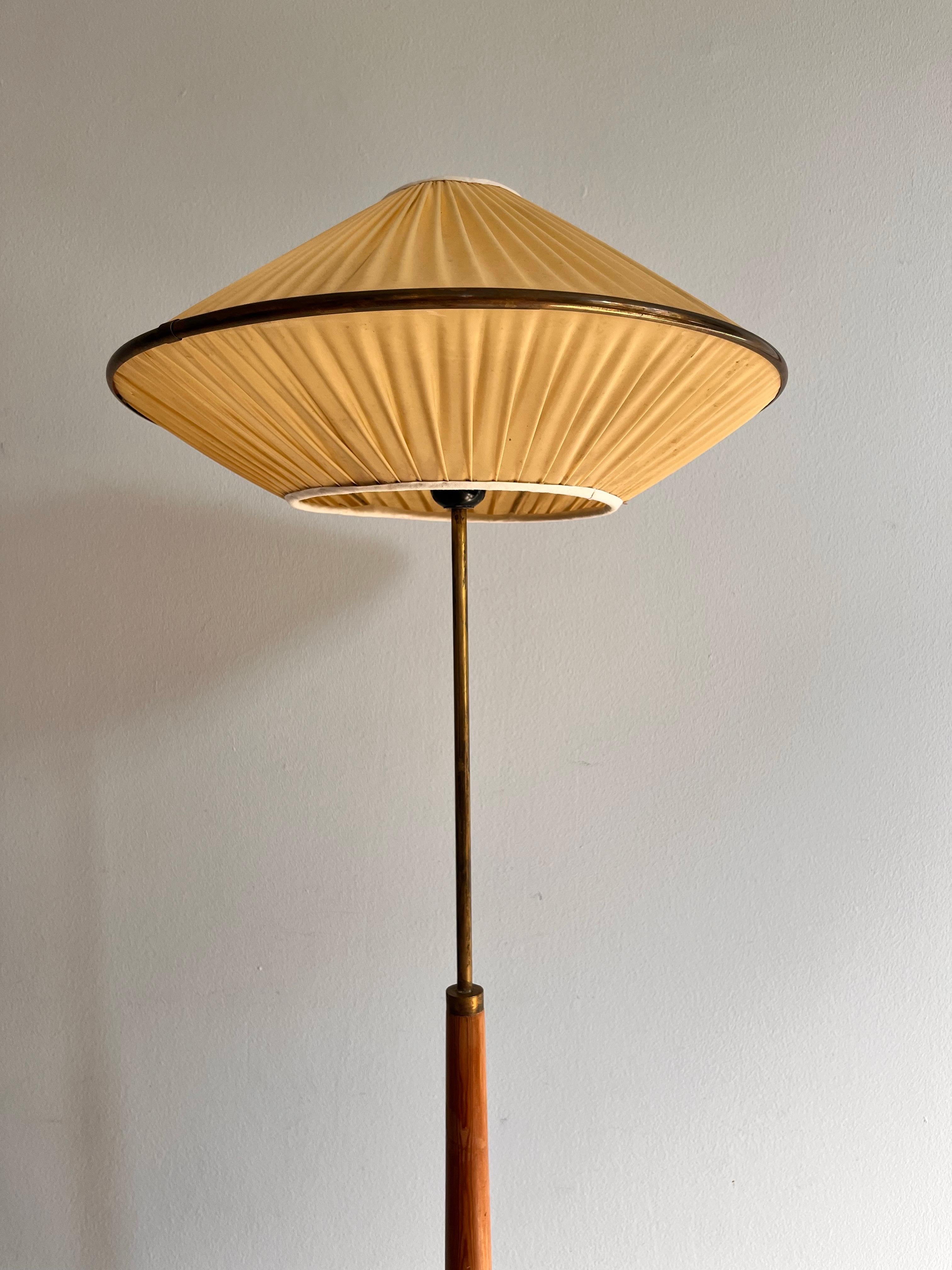 Lampada da terra unica con base in pino e ottone patinato. 

la lampada risale agli anni '60 ed è in ottime condizioni vintage. Una piccola crepa sul paralume. 

Il paralume è a forma di UFO e realizzato in plastica plissettata con un rivestimento