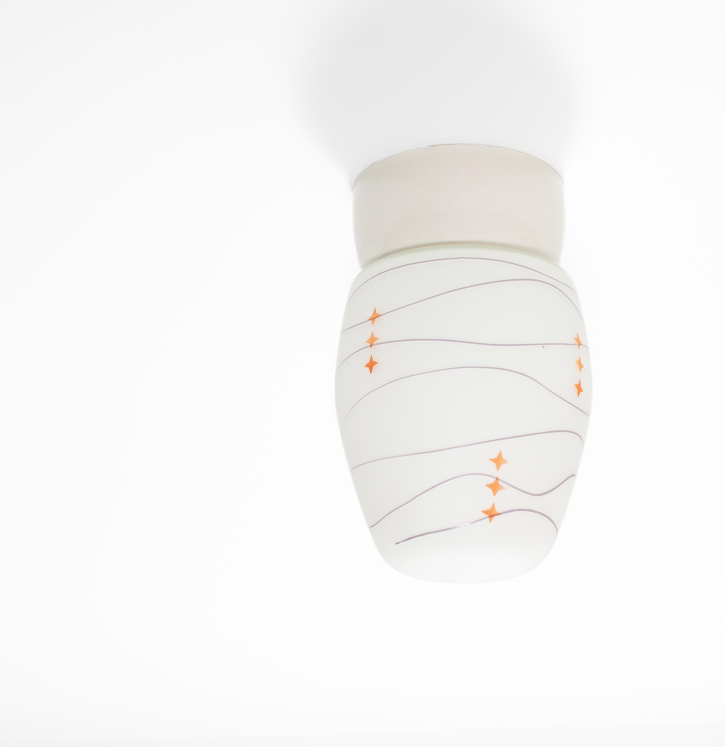 Wonderful ceiling light with decorated glass shade and base in porcelain. Designed and made in Norway from circa 1950s first half. The lamp is fully working and in very good vintage condition. The lamp uses a E27 bulb (works in the US), with a max