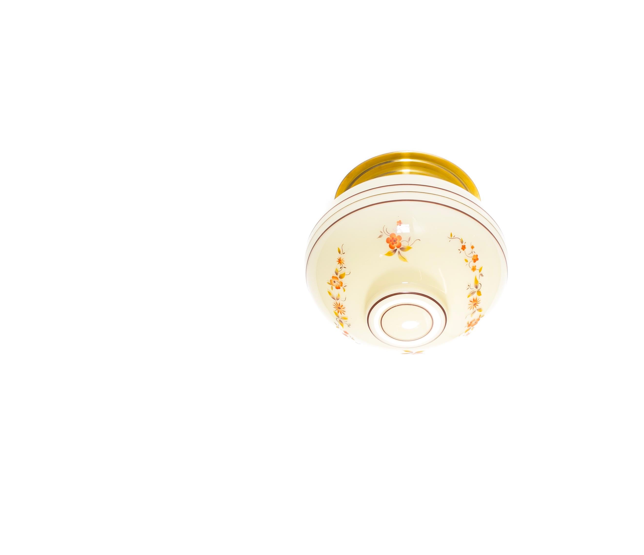 Wunderschöne und dekorative Deckenhalterung aus der ersten Hälfte der 1950er Jahre. Die Deckenleuchte hat einen cremefarbenen Glasschirm, der mit zarten handgemalten floralen Motiven in warmen Orange- und Grüntönen, kombiniert mit feinen rotbraunen