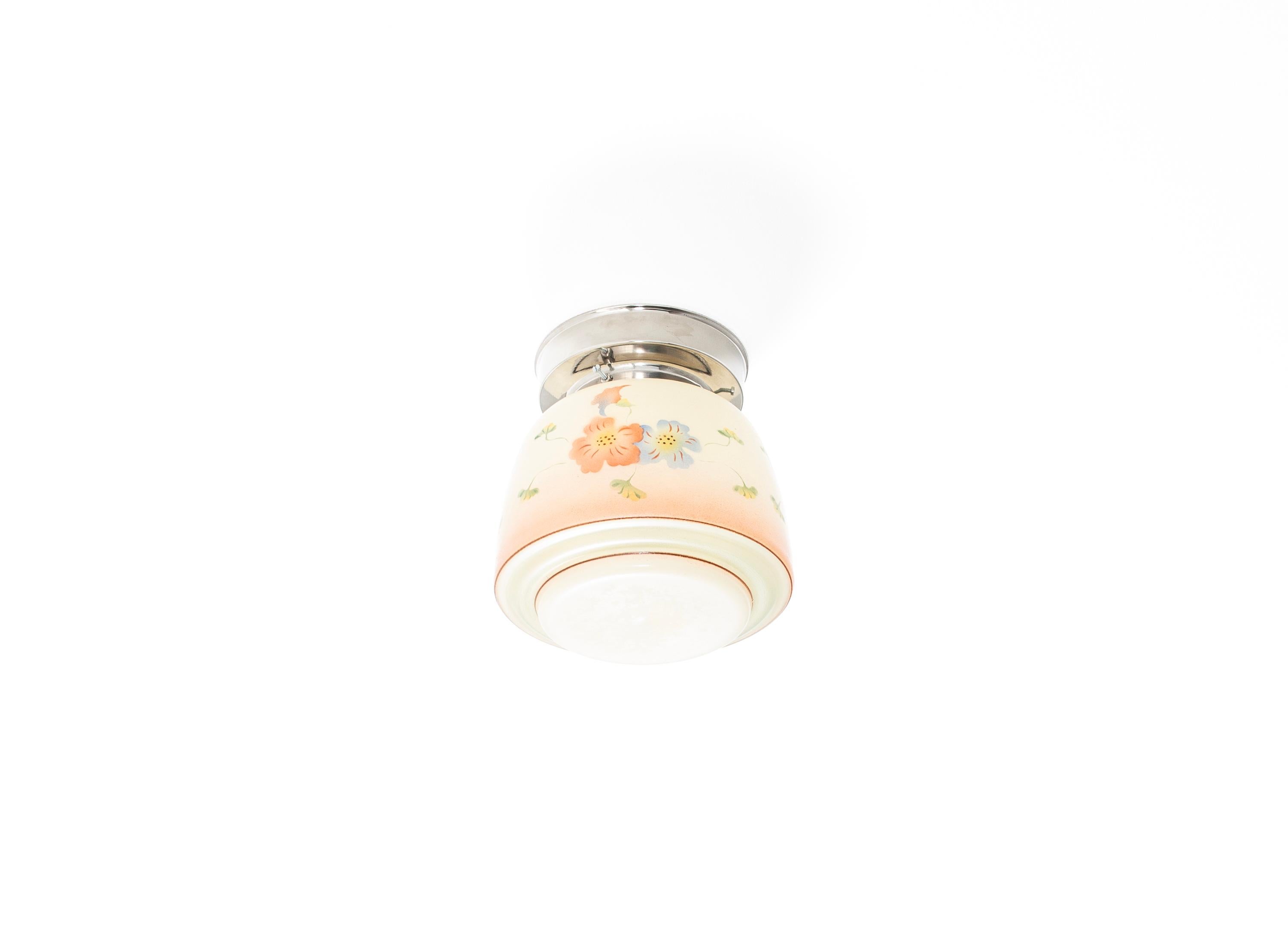 Decorative ceiling light featuring a glass shade that is hand-painted with delicate floral motifs in soft pastel tones. and a chrome metal base. Designed and made in Sweden from ca 1950s first half.

Ideal for kitchens, hallways, entryways, or