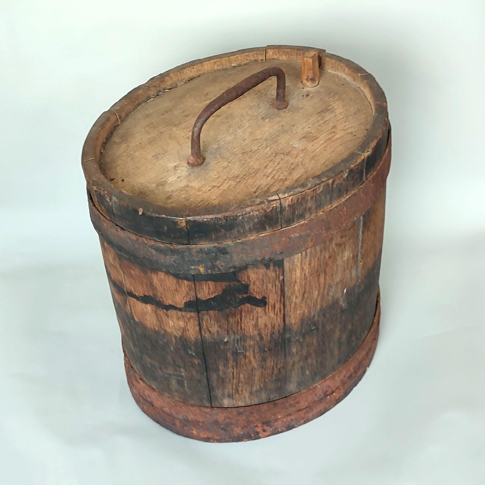 Botte in legno di quercia di arte popolare scandinava, realizzata nel XIX secolo e impregnata di tradizione rustica. 
Costruito con robuste doghe di quercia e fissato con un'autentica fascia di ferro, questo pezzo esemplifica la maestria dei primi