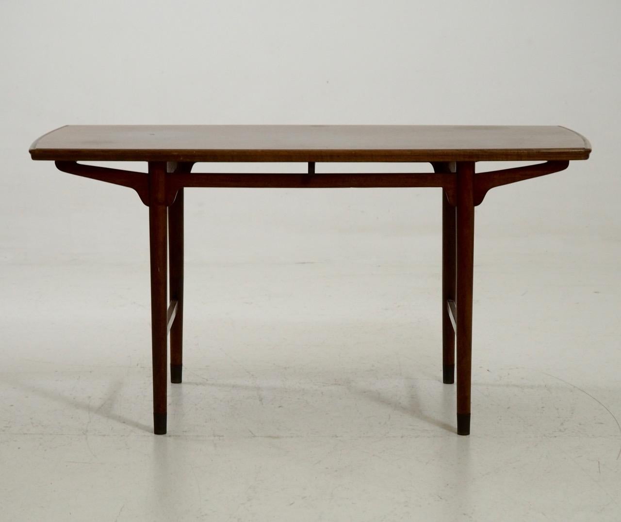 Fine table basse scandinave autoportante en teck, avec pieds en laiton, vers les années 1960.
Mesures : H. 62, L. 121, P. 62 cm.
H. 24.4, W. 47.6, D. 24.4 in.
 