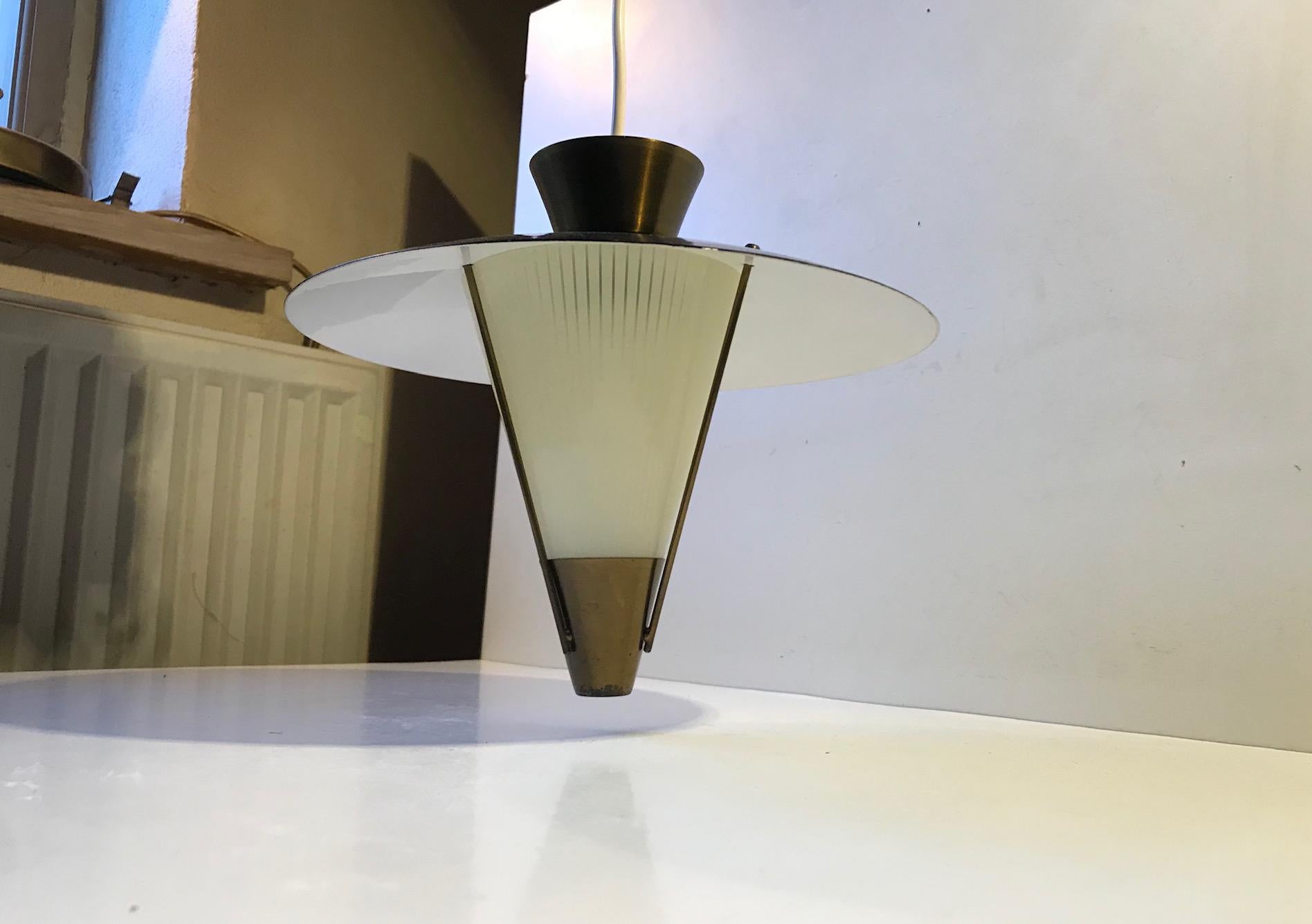 A Ballerina or spinning top shaped pendant lamp composed of a brass top, black lacquered aluminium shade and a brass supported conical shade in pinstriped glass. It was made in Scandinavia during the 1940s probably by either Voss Belysning in