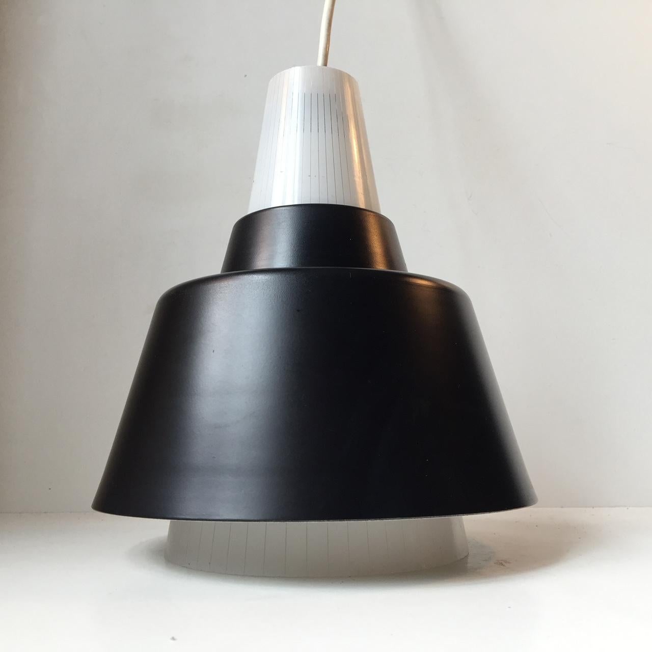 A Ballerina shaped pendant lamp composed of a black lacquered aluminium shade and a conical shade in pinstriped glass. It was made in Scandinavia during the 1940s probably by either Voss Belysning in Denmark or ASEA in Sweden. Measurements: H: 24,
