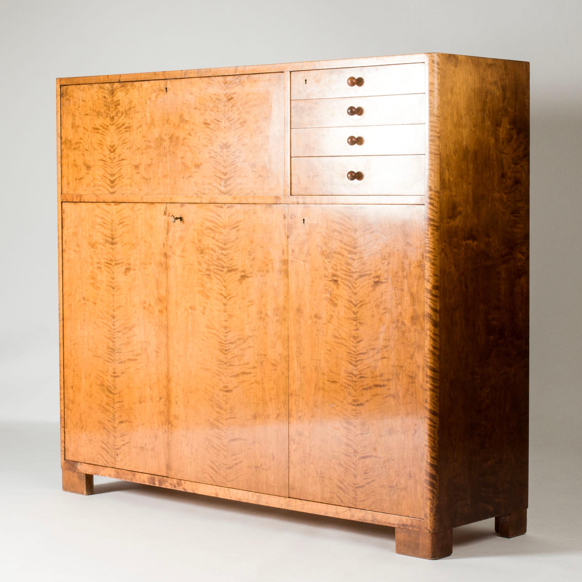 Large birch cabinet by Axel Larsson, in a functionalist design with a clean look. Appealing rounded corners and chunky feet. Nice darker wood ball-shaped handles on the drawers.