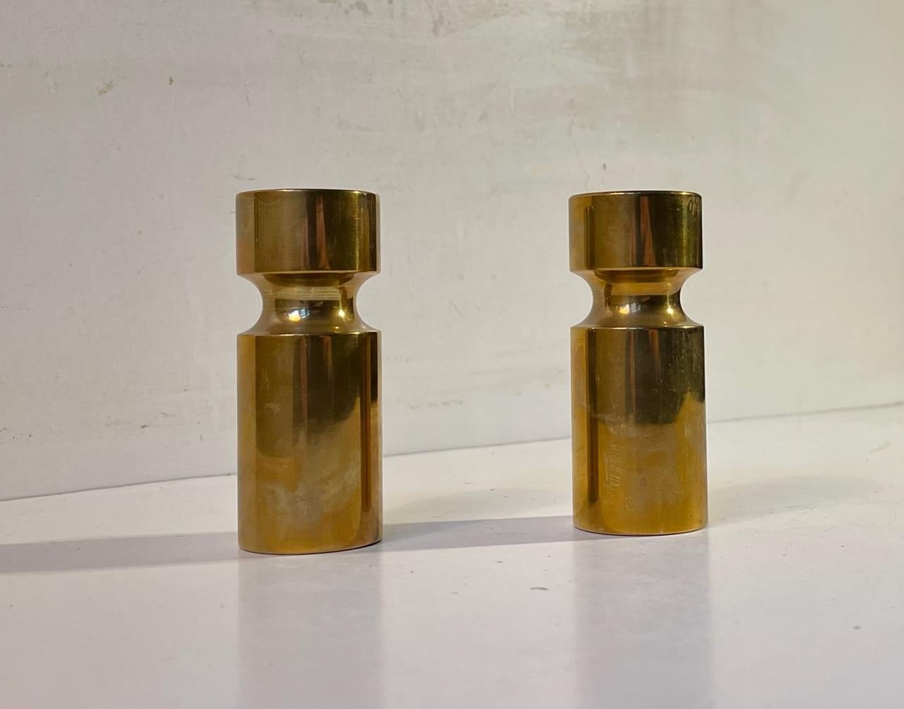 A pair of small yet heavy candle holders composed of engine-turned solid bronze. Their are to be installed with regular sized candles. Manufactured anonymously in Scandinavia during the 1930s or 40s. Measurements: H: 9.5 cm, D: 3.8 cm.