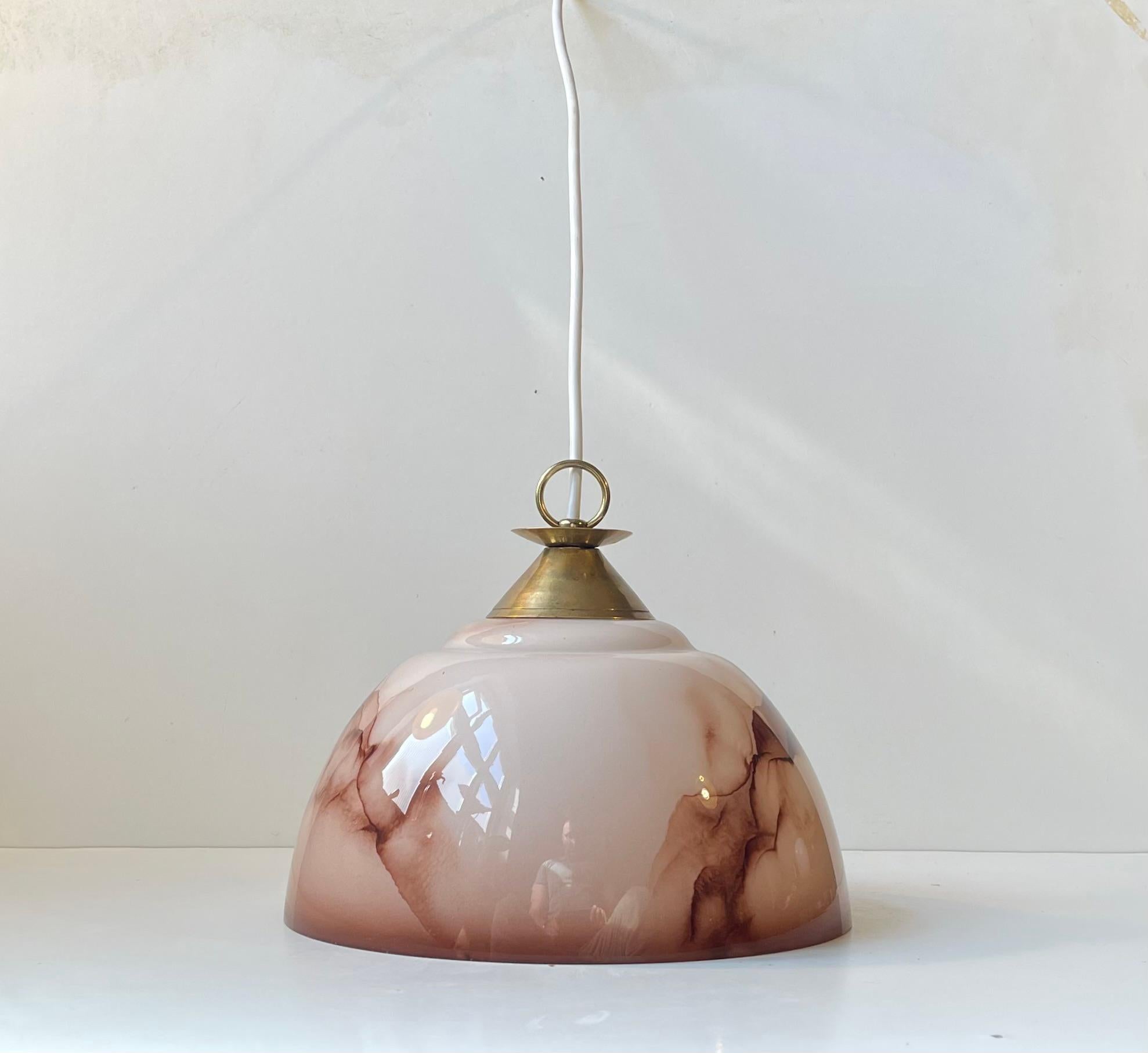 Sospensione pulita ed elegante composta da un paralume in vetro opalino rosa pastello decorato con effetti di marmo marrone. Presenta un piano in ottone massiccio patinato con un anello. Fu prodotto in Scandinavia negli anni '40. Lo stile