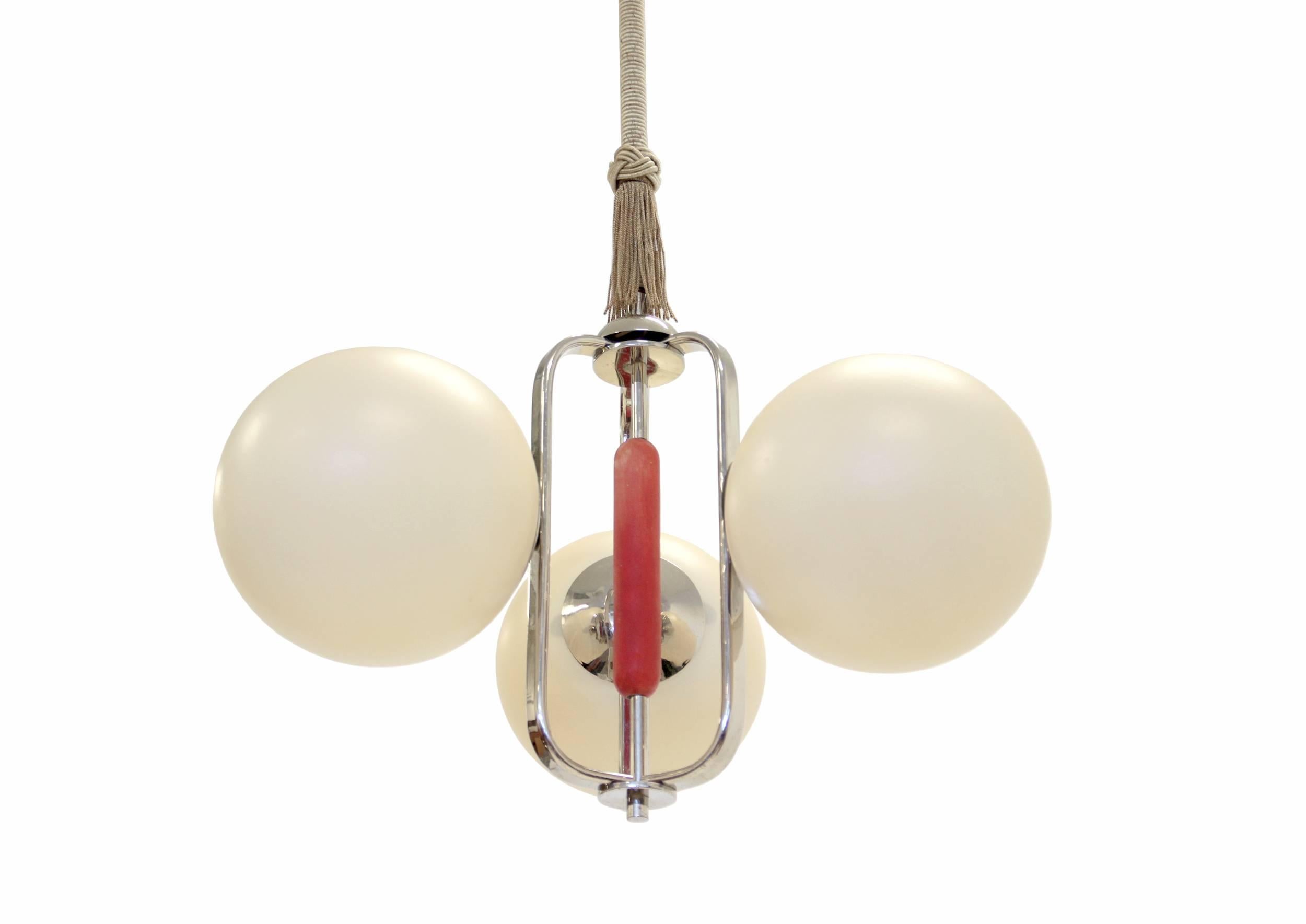 An exceptional and rare three-armed chandelier on a chromed steel frame with shades in opaline glass. The lamp is from the early 1950s when the 'funkis/functionalist' movement inspired by continental Bauhaus swept across Scandinavia. This particular