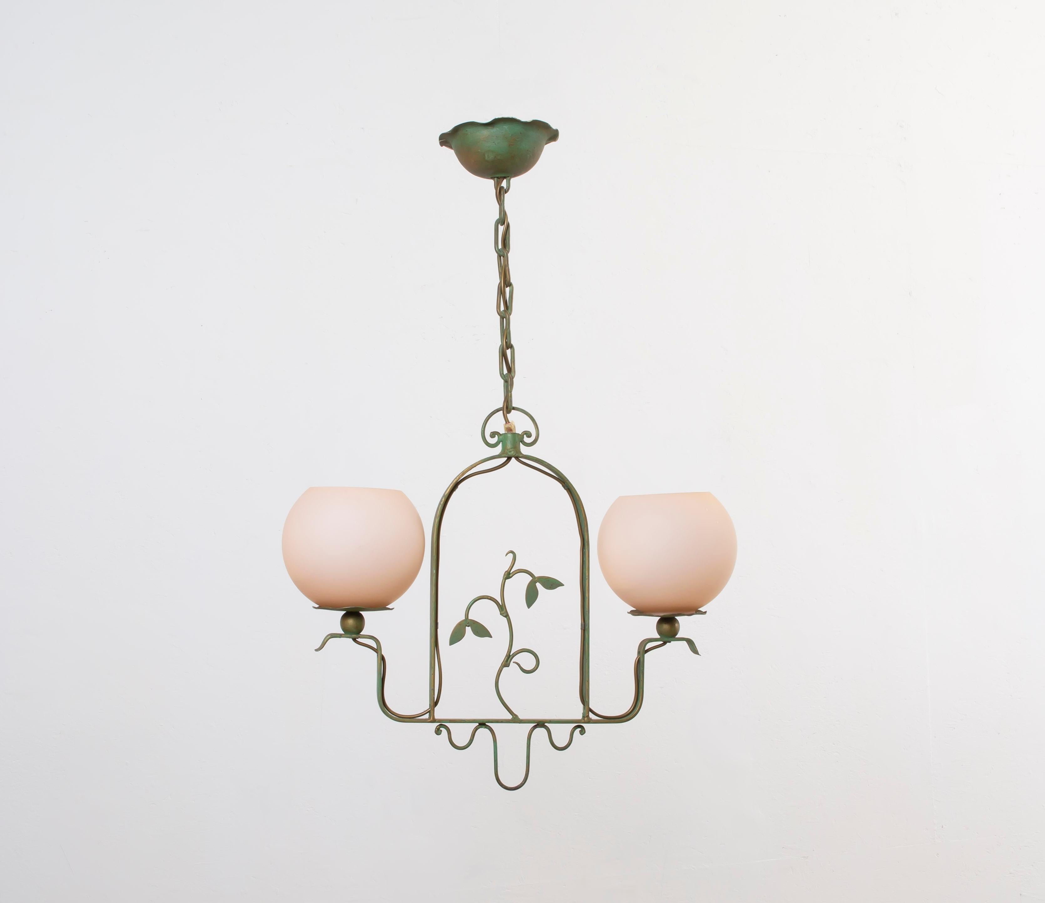 Wonderful and decorative ceiling light in painted metal with two shades in opaline glass. Designed and made in Norway from the first half of the 1950s.
The lamp is fully working and in good vintage condition. The lamp is fitted with two E27 bulb