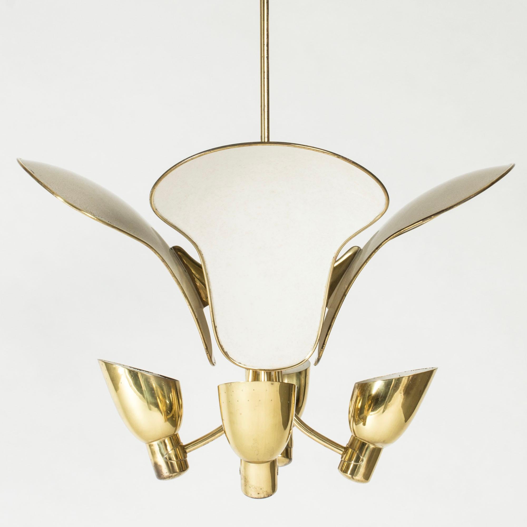 Striking chandelier by Carl-Axel Acking, in a singular design made in brass. Large, white lacquered petals reflect the upward light from the four polka dot perforated shades and also enclose two light sockets on the top of the fixture.