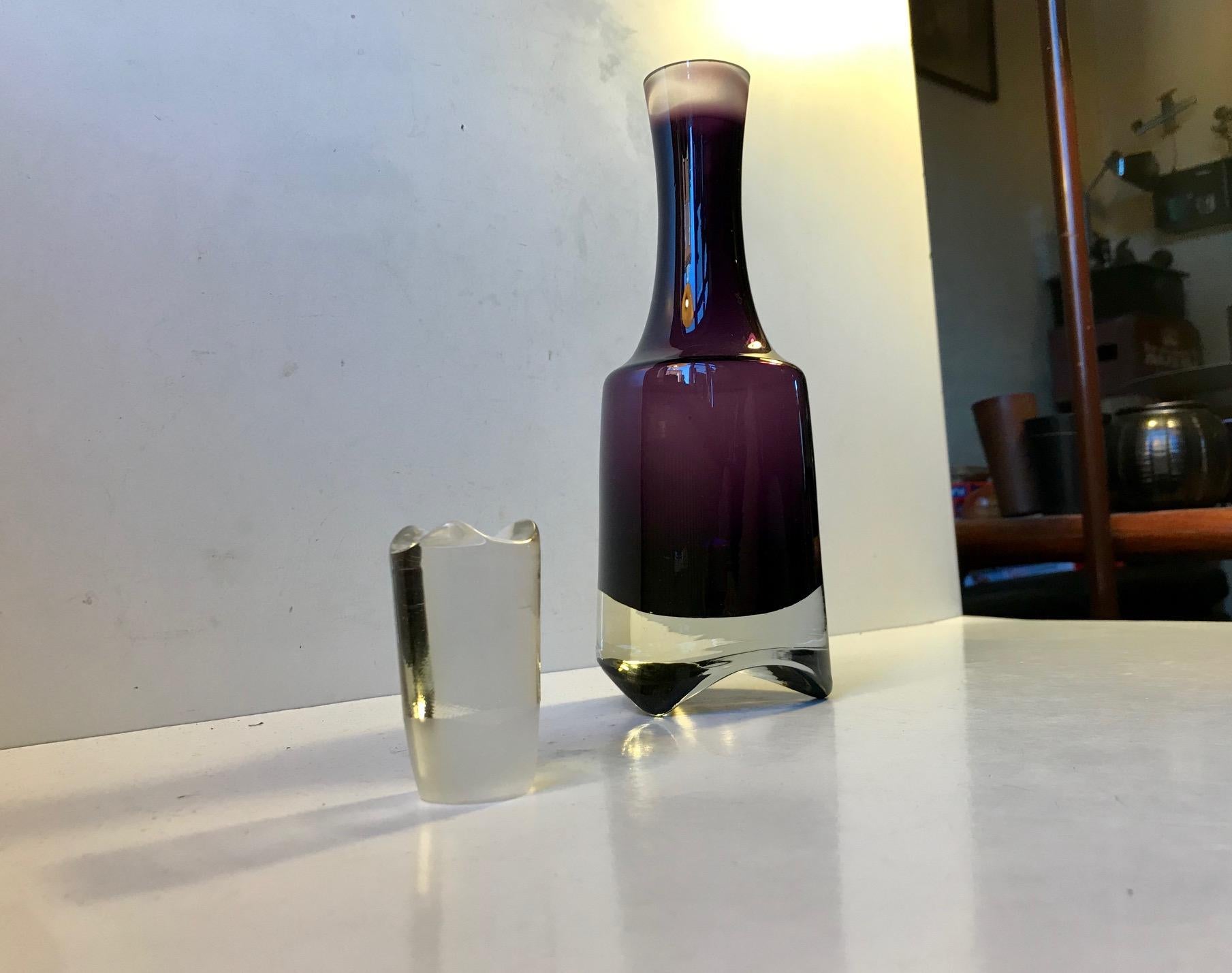Un decantador de estilo modernista/brutalista para ginebra o vodka. Está hecho de cristal summerso amatista. Fíjate en que la formación del tridente hasta el fondo coincide con la forma del tapón. Se fabricó en Escandinavia en la década de 1970,