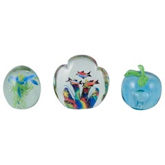 Scandinavian glass artist. Set of three paperweights in art glass.