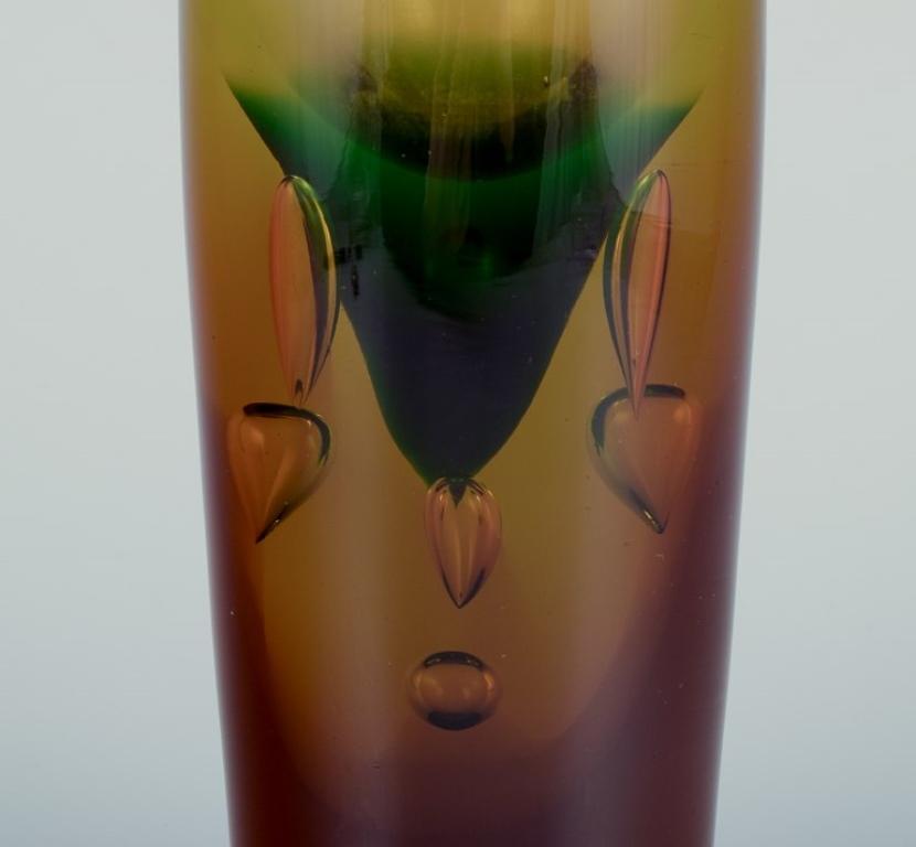 Artista del vetro scandinavo, vaso in vetro artistico alto e sottile.
Soffiato a bocca. Vaso pesante.
Vetro ambrato e verde con bolle d'aria incorporate.
Dagli anni '60.
Non timbrata.
In ottime condizioni, con segni d'uso.
Piccola scheggiatura