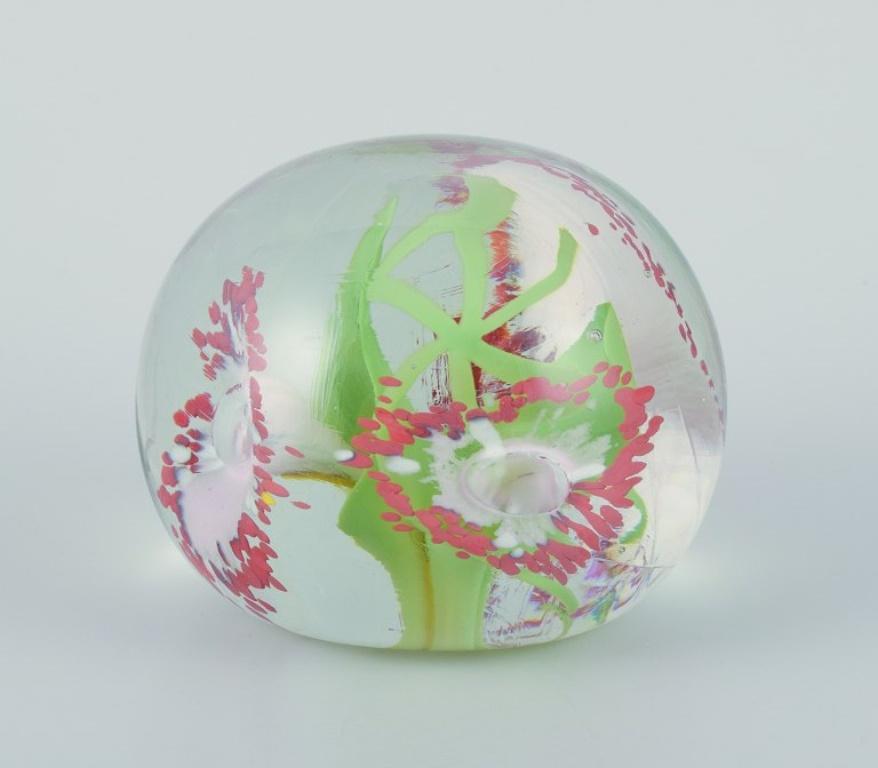 Scandinavian glass artist. Set of three paperweights in art glass. 
Flower motifs and more embedded in the glass. Handmade.
Around the 1980s.
In perfect condition.
Dimensions: H 6.0 - 11.5 cm x D 7.0 - 8.0 cm.