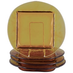 Scandinavian glass designer. Set of four plates in smoke-coloured art glass.