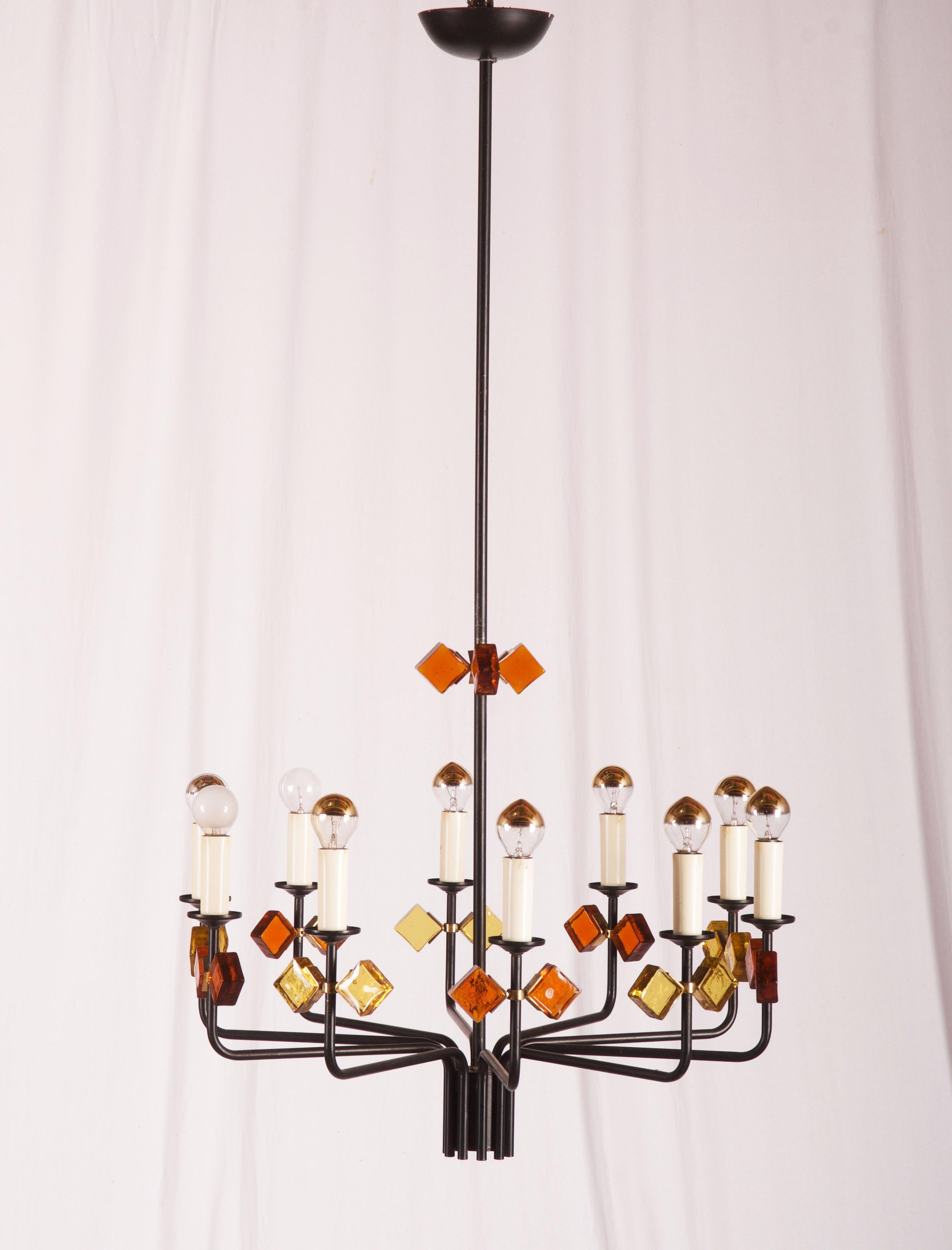 Iron frame black painted with yelow and orange glass elements fixed with brass ring and holders. Fitted with ten E14 sockets. Designed in Danmark in the 1950s by Svend Aage Holm Sorensen for Holm Sorensen and Company.
      