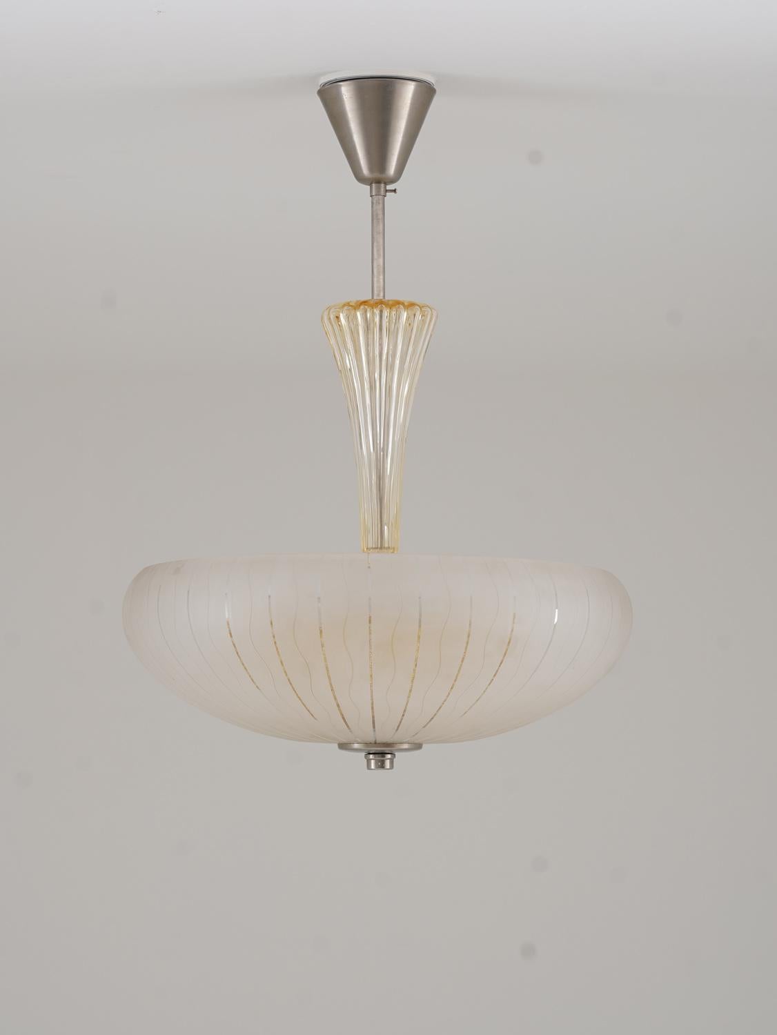Un'elegante lampada a sospensione di Orrefors, realizzata negli anni '50, che combina un design senza tempo con un'esperta lavorazione artigianale. La lampada presenta un sorprendente paralume in vetro a doppio strato: il paralume esterno in vetro