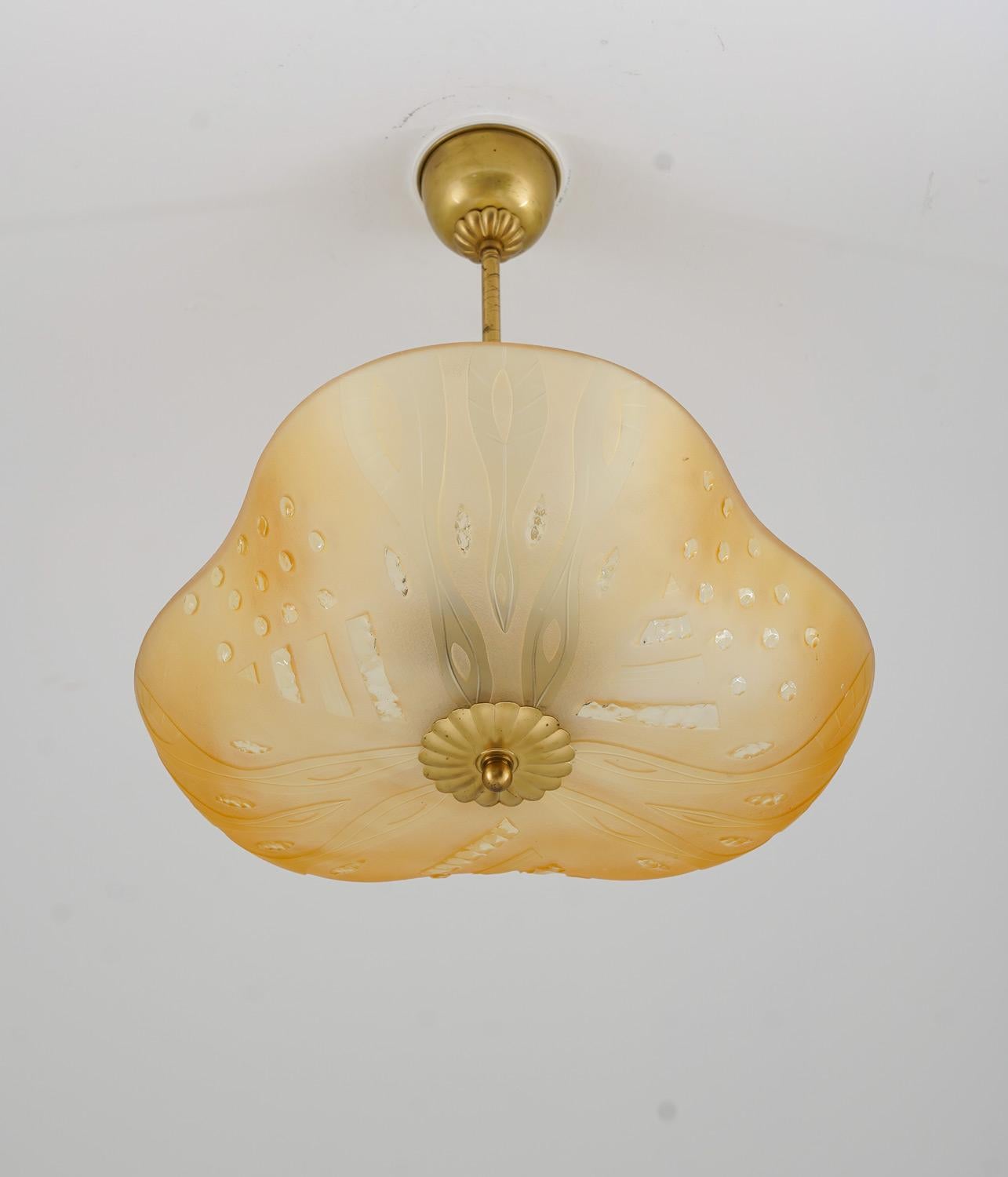 Beautifully shaped pendant in brass and frosted glass, most likely produced by Orrefors in Sweden circa 1940. 
The frosted amber-colored glass gives a beautiful and soft light. 
The rod can be shortened to create a flush mount

Condition: Good