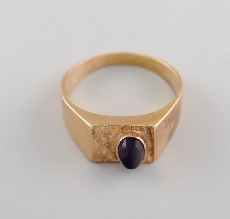 Scandinavian goldsmith. 14-carat modernist gold ring adorned with dark amethyst. Mid 20th century.
Diameter: 18 mm.
US size: 7.75.
In very good condition.
Stamped.