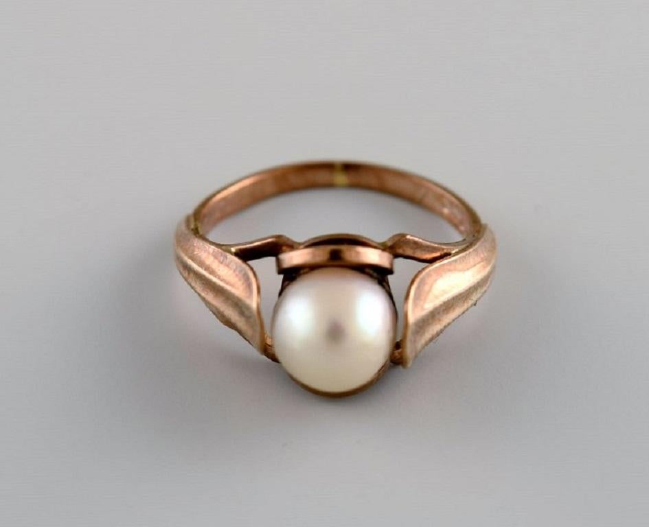 Scandinavian goldsmith. Vintage ring in 14-carat gold adorned with cultured pearl. 
Mid-20th century.
Diameter: 14 mm.
US size: 3.
In excellent condition.
Stamped.
Measured to 14 carats by jeweler.
In most cases, we can change the size for a fee (50