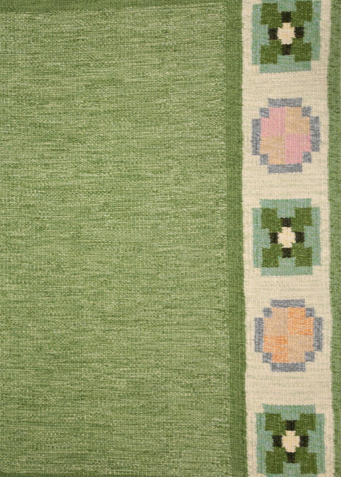 Scandinavian rug from the 60's by the Swedish artist Ingegerd Silow. Flat weaving technique (rillakan), wool on linen. Traditional geometrical patterns in green, pink and beige. Handwoven in Sweden in the 50s/60s. Excellent vintage condition (see
