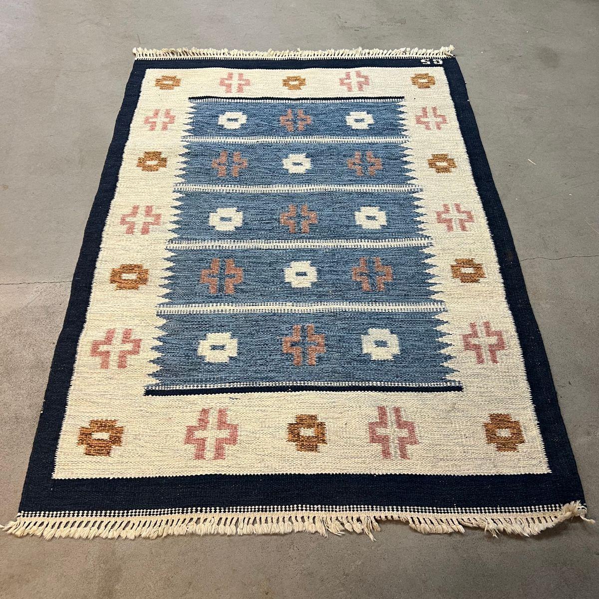 Tappeto scandinavo a tessitura piatta (Röllakan),  firmato GS, Svezia, metà del XX secolo.
Tessuto piatto intrecciato a mano (Röllakan). Iniziali tessute 