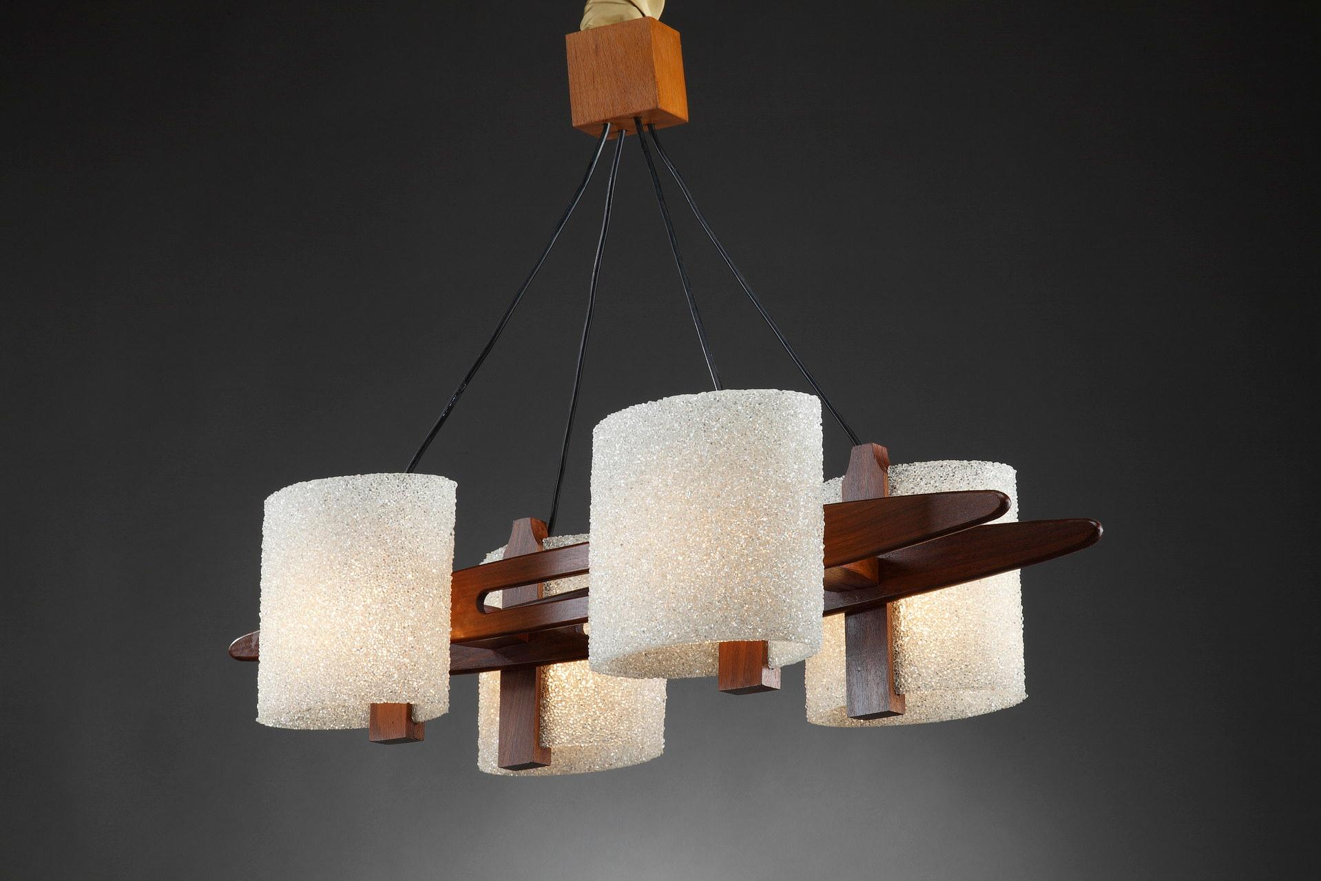 Scandinavian style hanging lamp in teak and exotic wood with granite perspex lampshades. It is suspended by four black wires and is attached to the ceiling by a teak cube. This four light chandelier is typical of the Scandinavian design of the