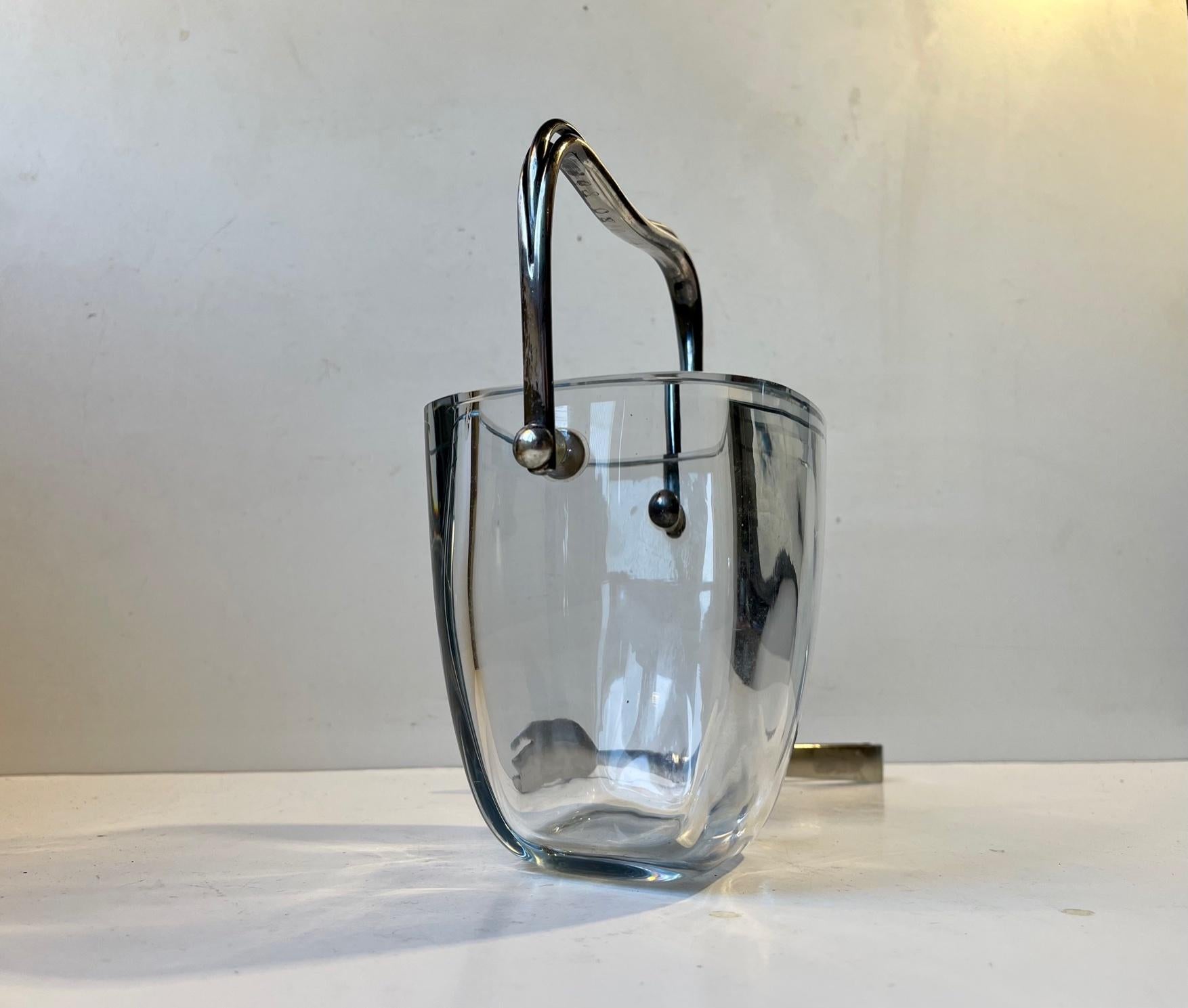 Strömbergshyttan ice bucket with hand made sterling handles. Crafted of Strömbergshyttan glass with it's characteristic light blue hue. The handles are made from solid sterling silver and features a partially split stylish 3-armed design . Vaguely