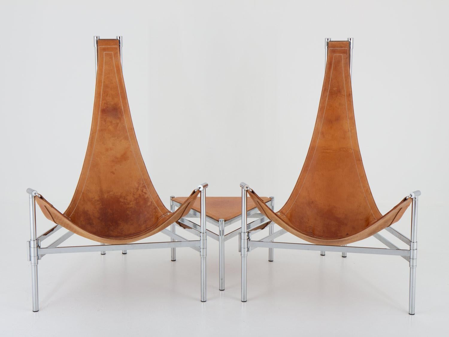 Rare armchairs and side table in chrome and leather by Christina and Lars Andersson, 1980s. 
This chairs consist of a chromed metal frame, supporting the thick Tärnsjö saddle leather used for the seating. The cognac-coloured leather shows a perfect