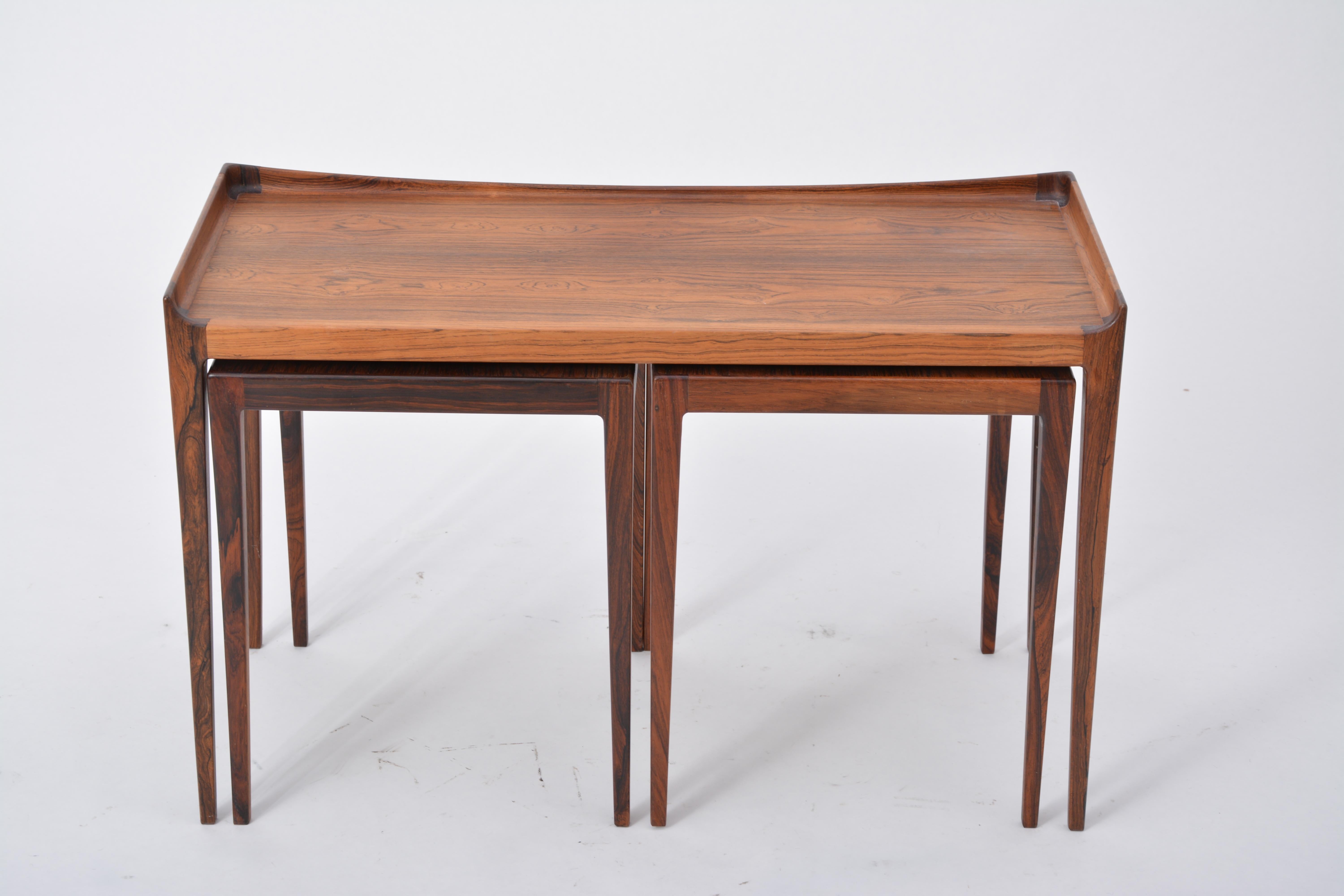 Set of three nesting tables made of rosewood, designed by Kurt Ostervig in 1958, produced by Jason mobler in Denmark. The set consists of one rectangular table (length 79.5 cm x depth 35.5 cm, height 50 cm) and two square tables (L 35.5 cm x W 35.5