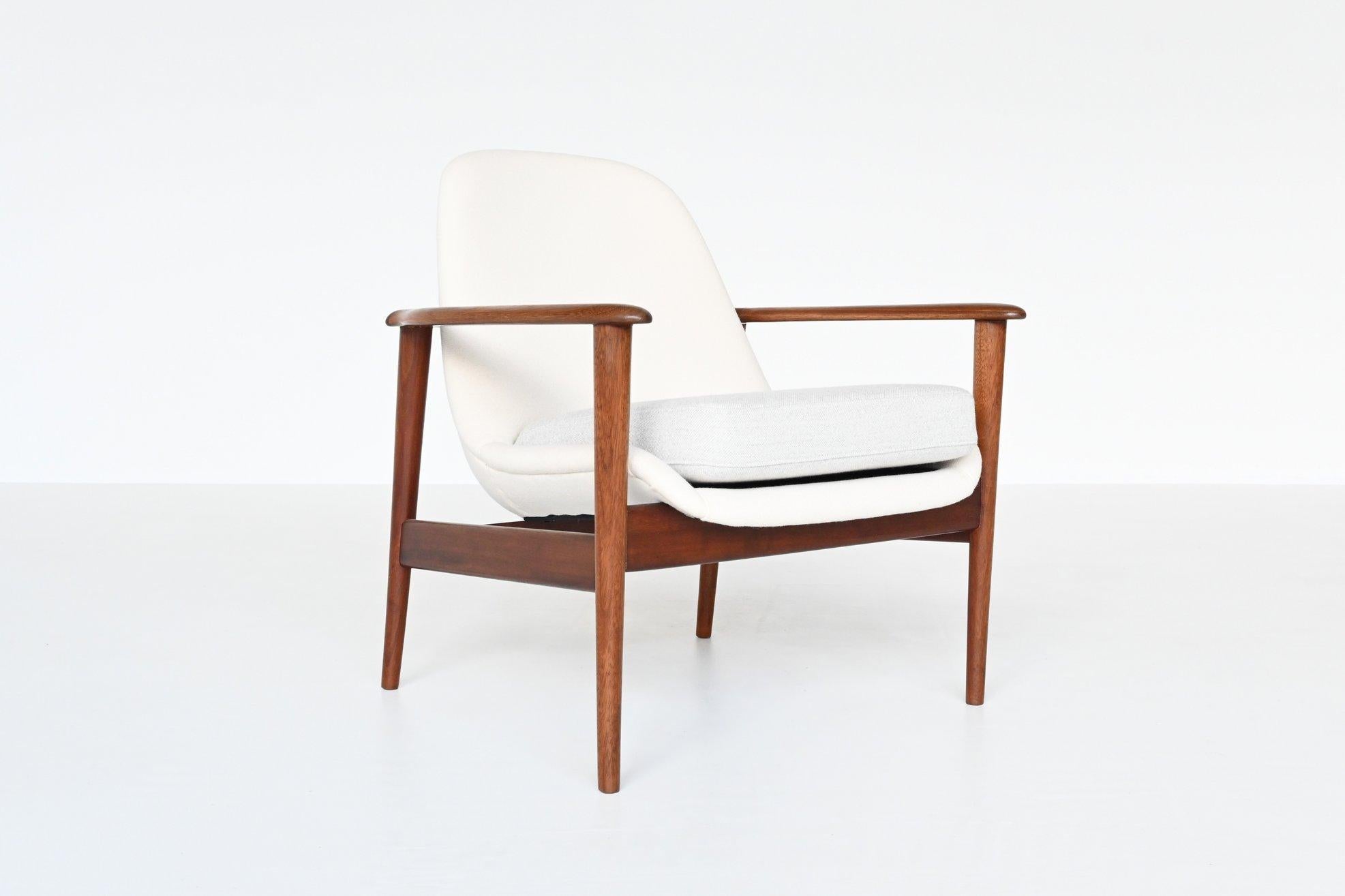 Beautiful shaped Scandinavian lounge chair in the style of IB Kofod Larsen and Arne Hovmand-Olsen, Denmark 1960. This chair has a solid teak wooden frame and it is newly upholstered with white and grey wool upholstery. The teak wooden frame flows