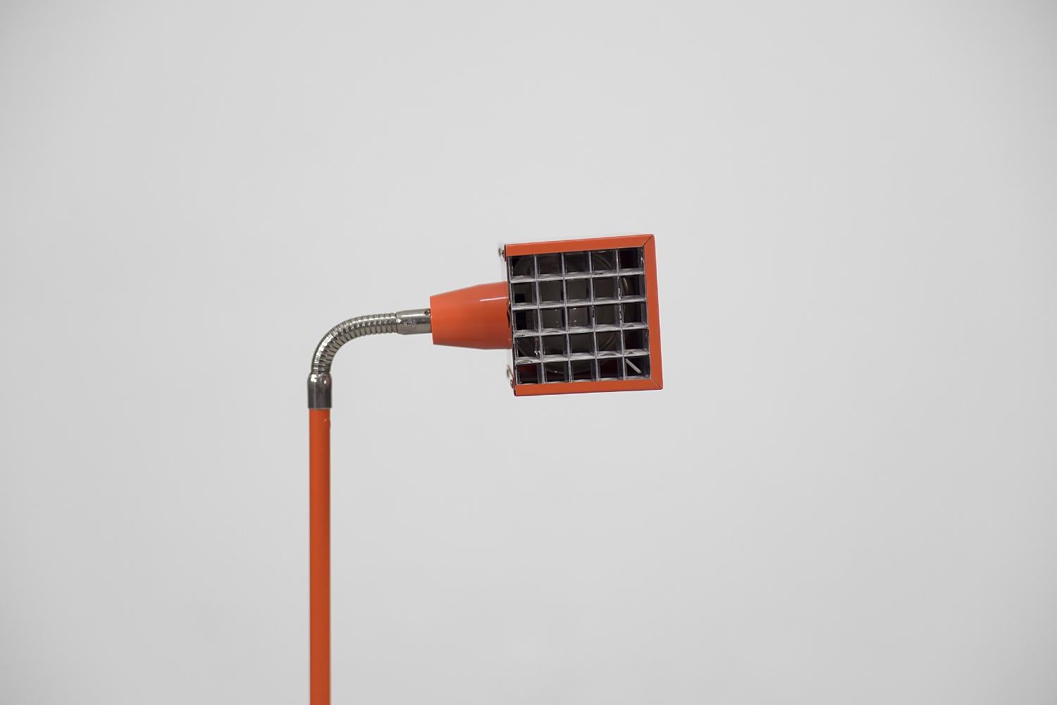 This Kuben floor lamp was designed by Björn Svensson for the Swedish Elidus manufacture during the 1970s. The cube-shaped lamp is made of metal in the iconic orange-red color. It has a flexible element at the lampshade that makes it easy to change