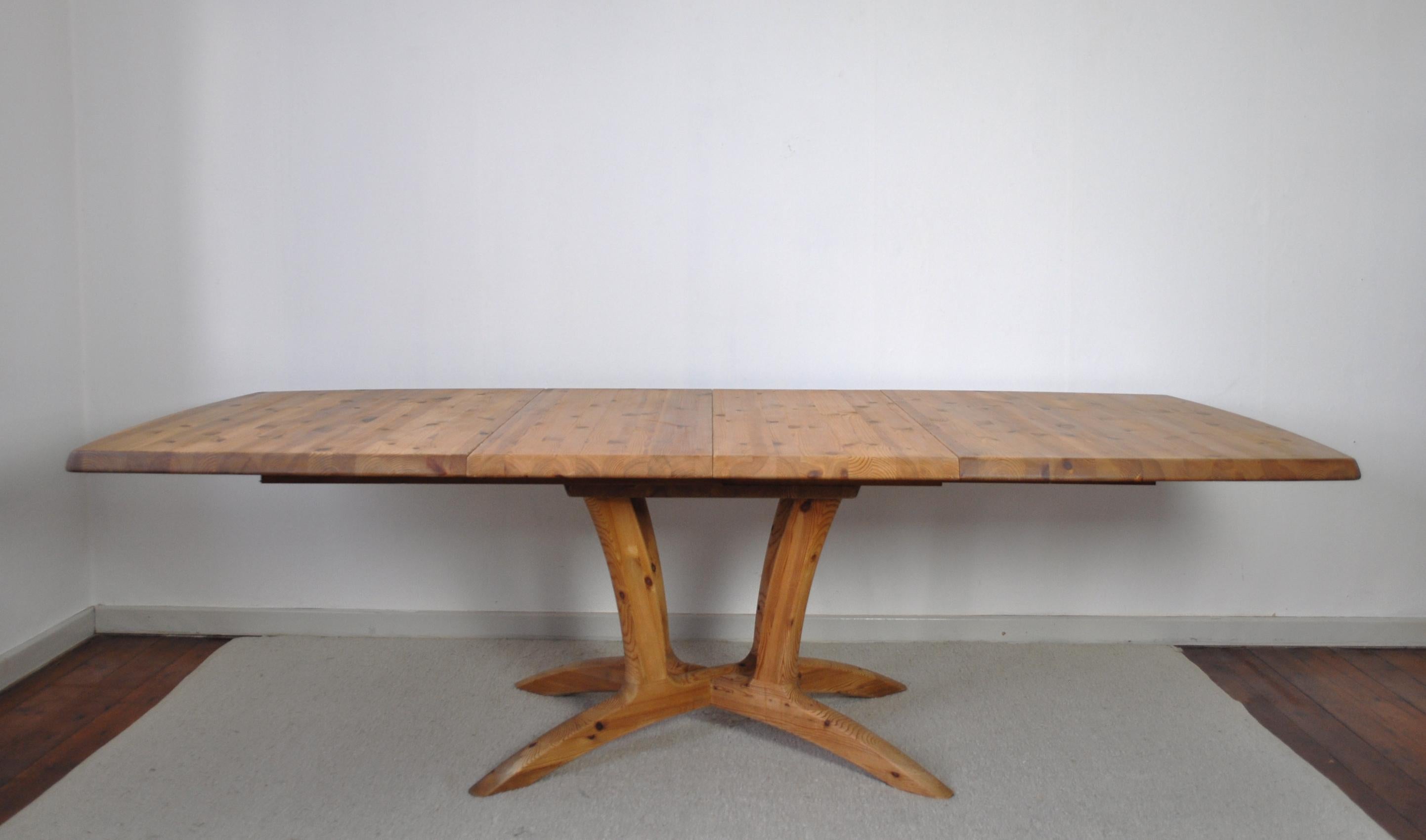 Large modern Scandinavian dining table in solid pine wood. Organic shaped legs, solid pine wood with a beautiful grain, two expandable leaves. Great craftsmanship. 
Signs of wear consistent with age and use which can be repaired by our cabinetmaker.