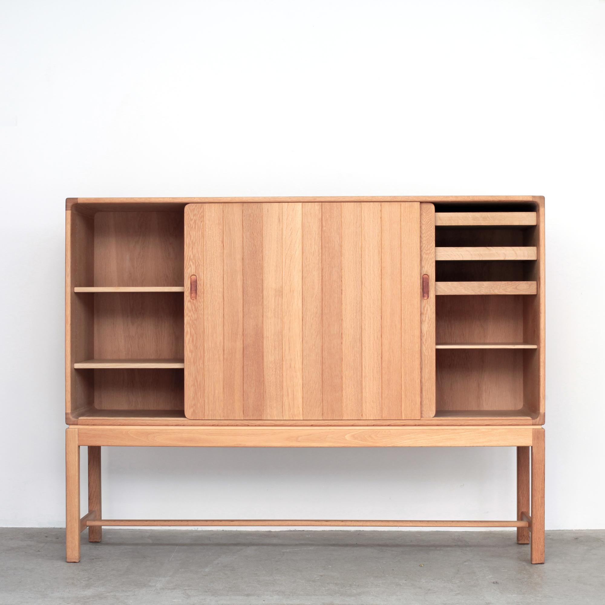 Rare light oak cabinet by Kurt Østervig for KP Mobler. Denmark 1970s.
Two sliding doors with handles covered in leather,
3 drawers and 5 height-adjustable shelves.