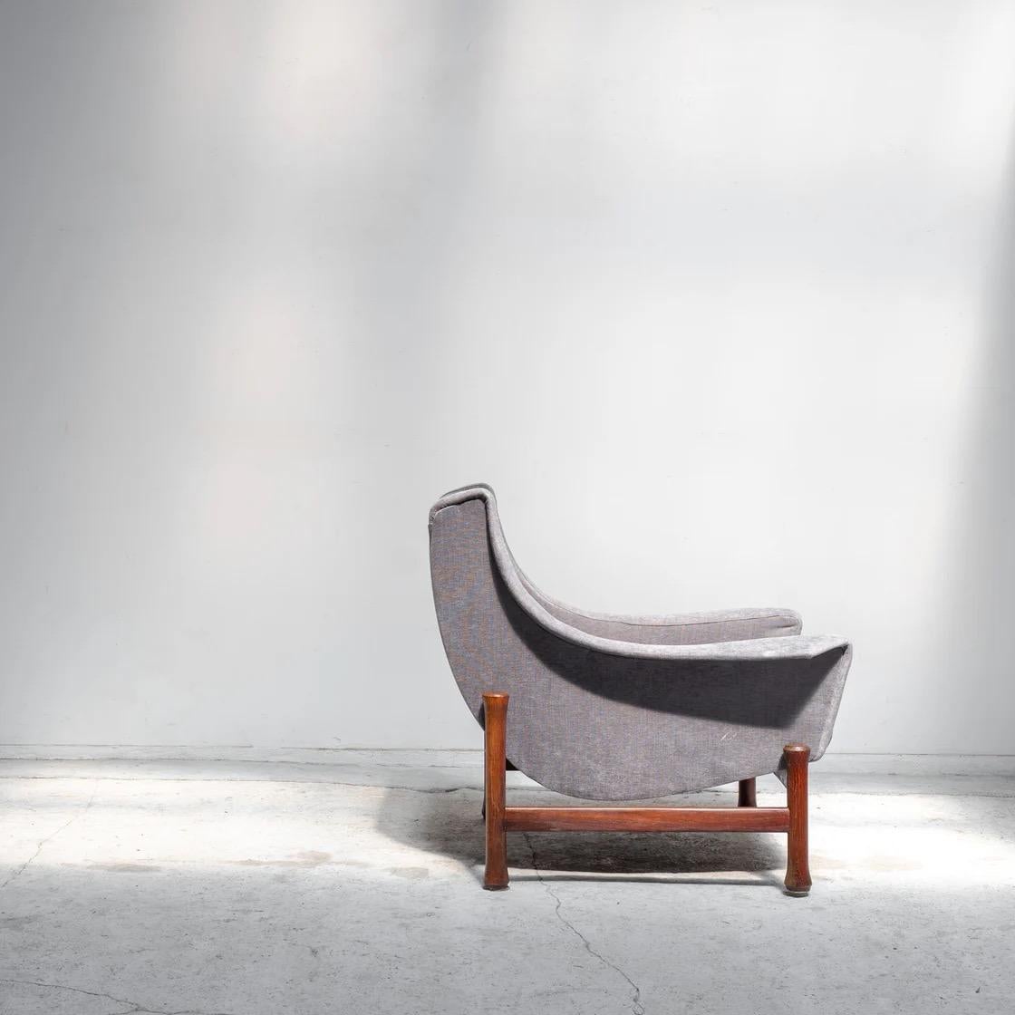 A distinctive vintage lounge chair featuring an enveloping curved form and a solid wooden base. Its sculptural silhouette seamlessly blends comfort with refined proportion, evoking the quiet sophistication characteristic of Scandinavian modern