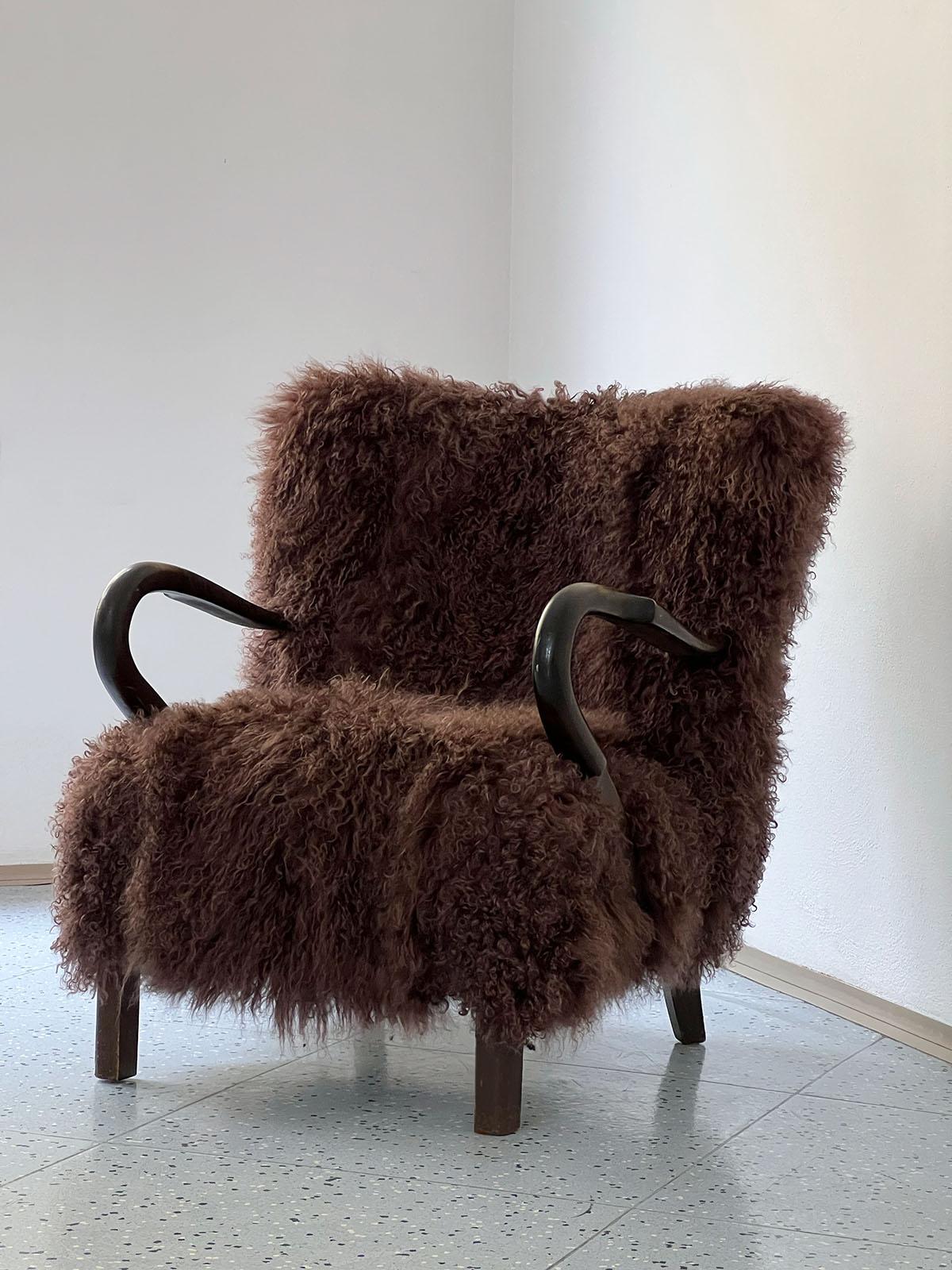 Scandinavian wooden lounge chair, made in Sweden in the 1940s and newly upholstered in brown Tibetan wool.

The lounge chair features beautifully curved armrests which blend perfectly with the brown Tibetan wool upholstery, giving the chair a