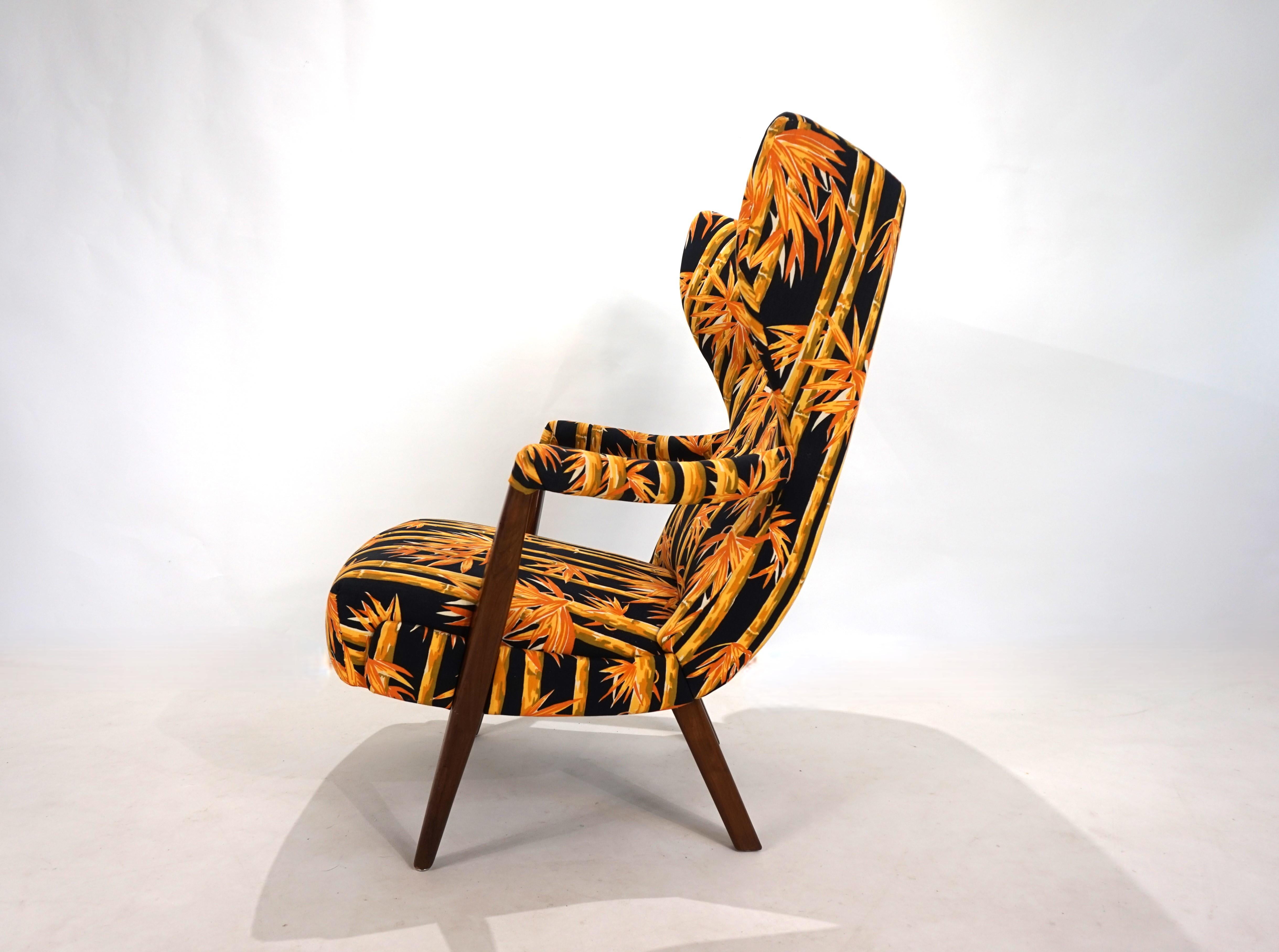 This lounge chair, with its striking lines, is in near-new condition. The fabric, with its stunning pattern of large bamboo motifs on a black background, commands all the attention in the room. It shows virtually no signs of wear. The upper armrests