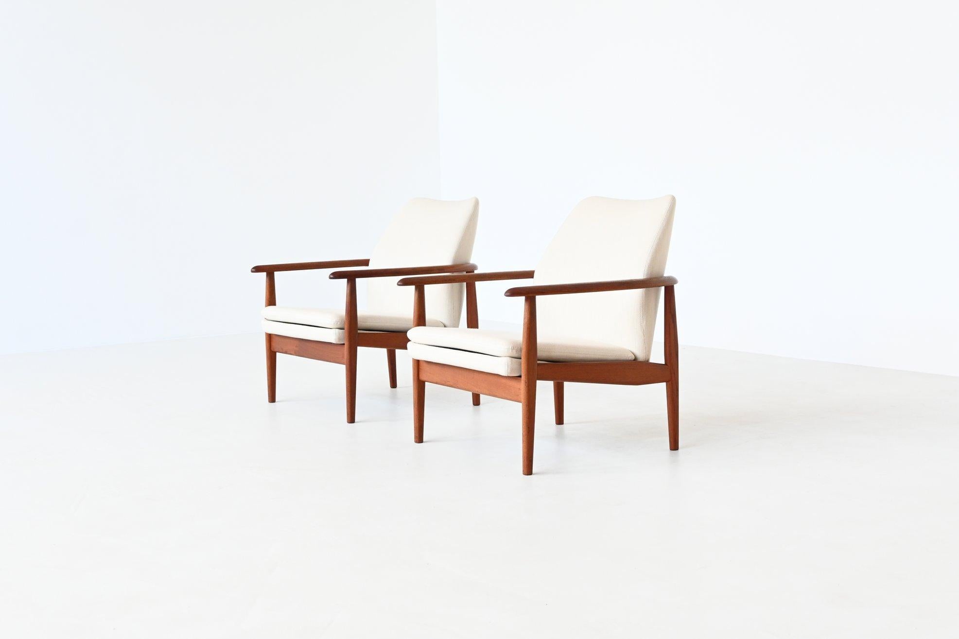Beautiful shaped pair of lounge chairs by unknown designer or manufacturer, Denmark 1960. These sculptural chairs feature a solid teak wooden frame and the shells and cushions are upholstered with off-white linen fabric. Typical example of high