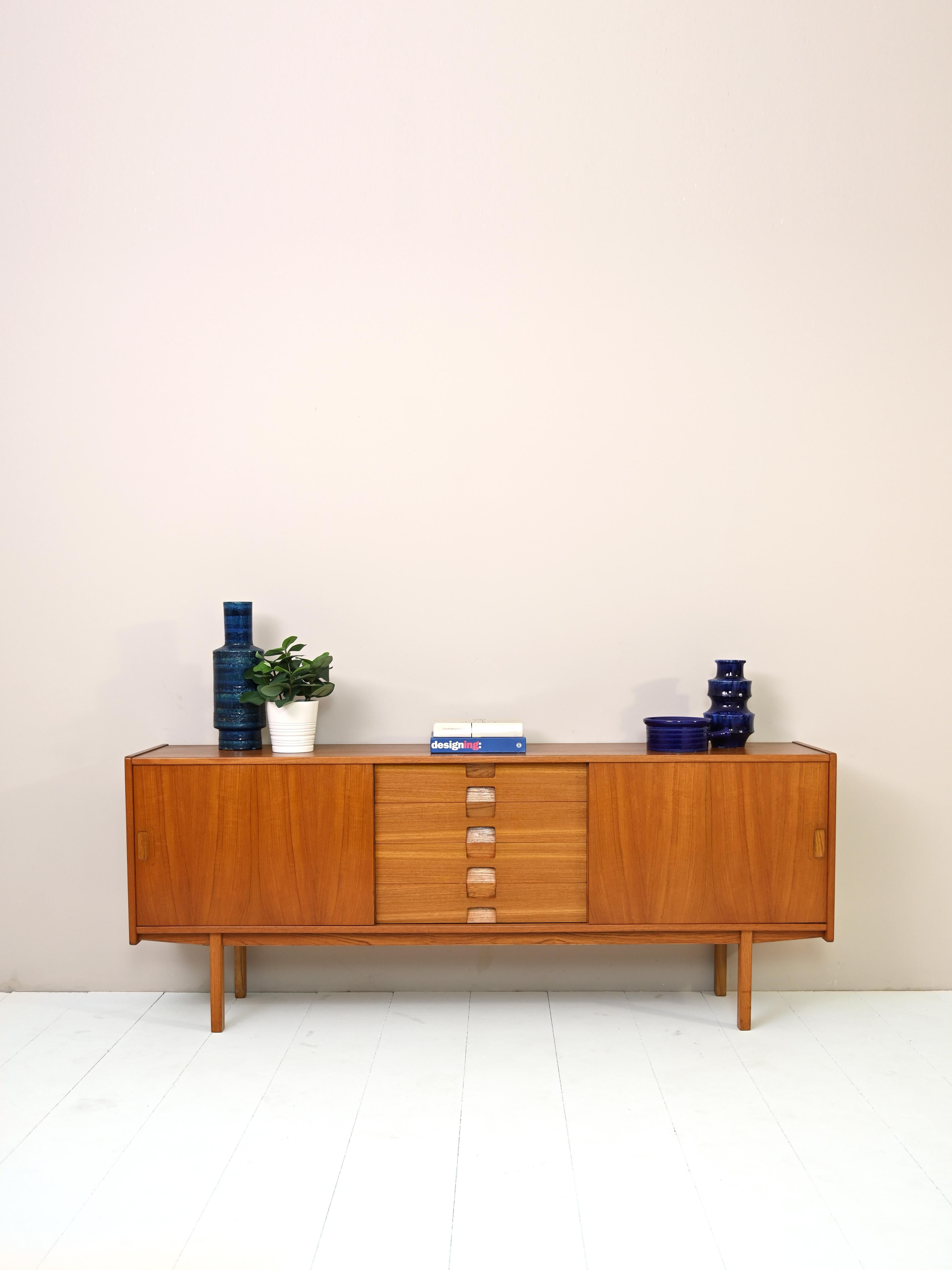 Original Scandinavian vintage sideboard and bar cabinet.
A distinctive and iconic mid-century piece that, thanks to its small size, fits in different rooms in the house.
It features on one side a storage compartment with a drop-down door equipped